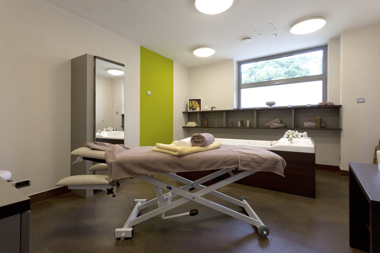 Exclusive spa room with high-quality floor tiles and a relaxation lounger.