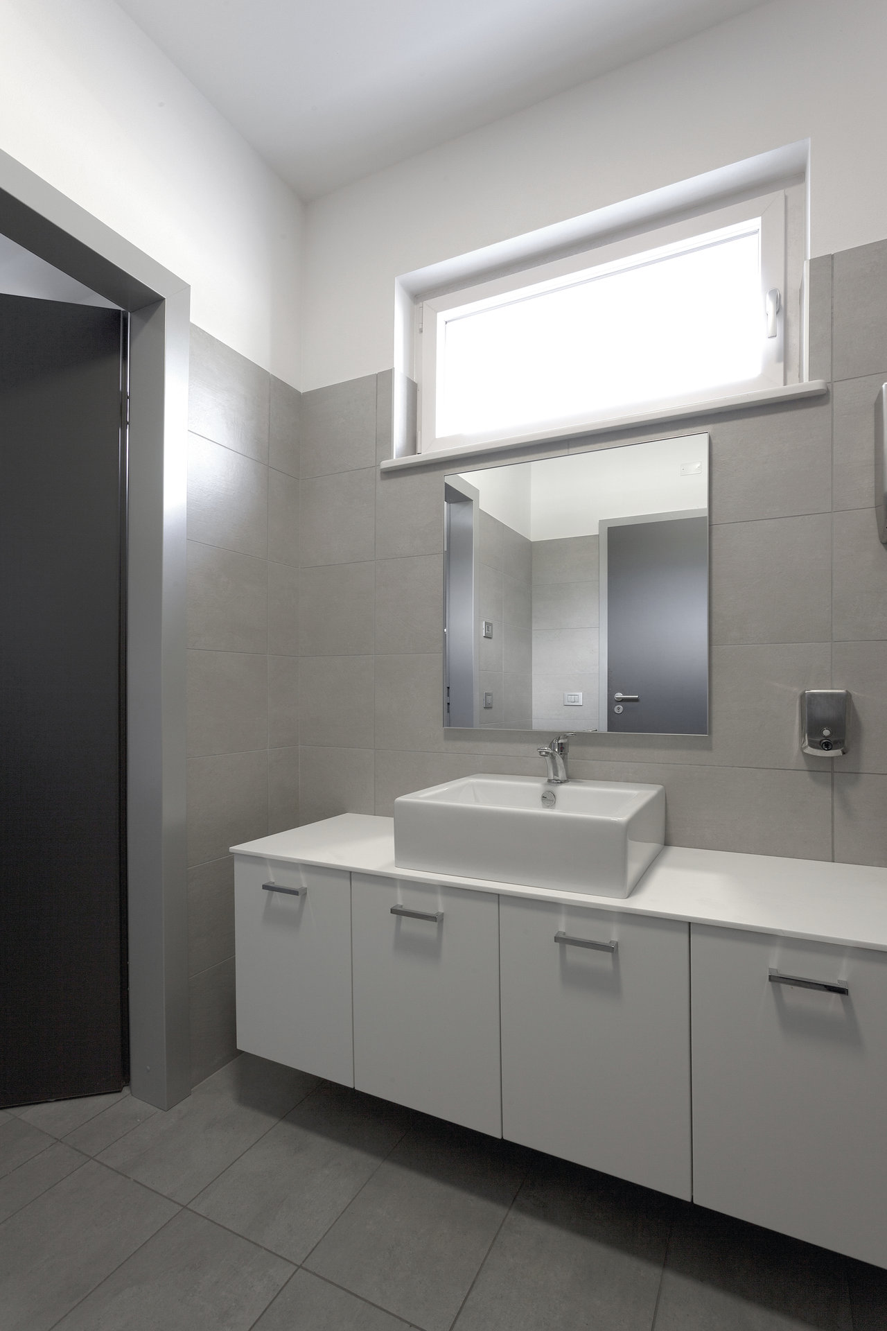 Contemporary bathroom with large-format grey tiles and elegant vanity.