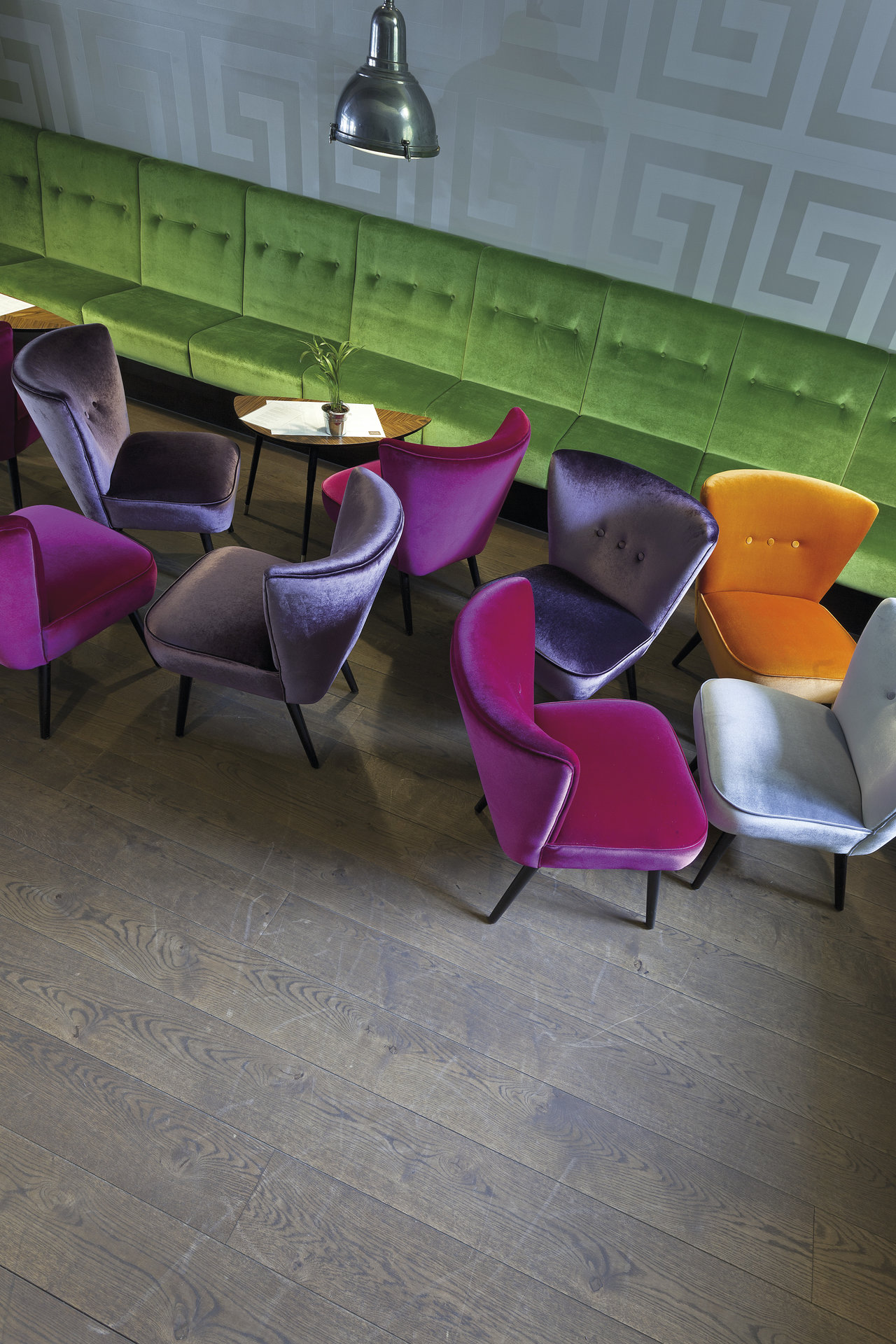 Modern wood-look tiles in a stylish room with colourful velvet chairs.