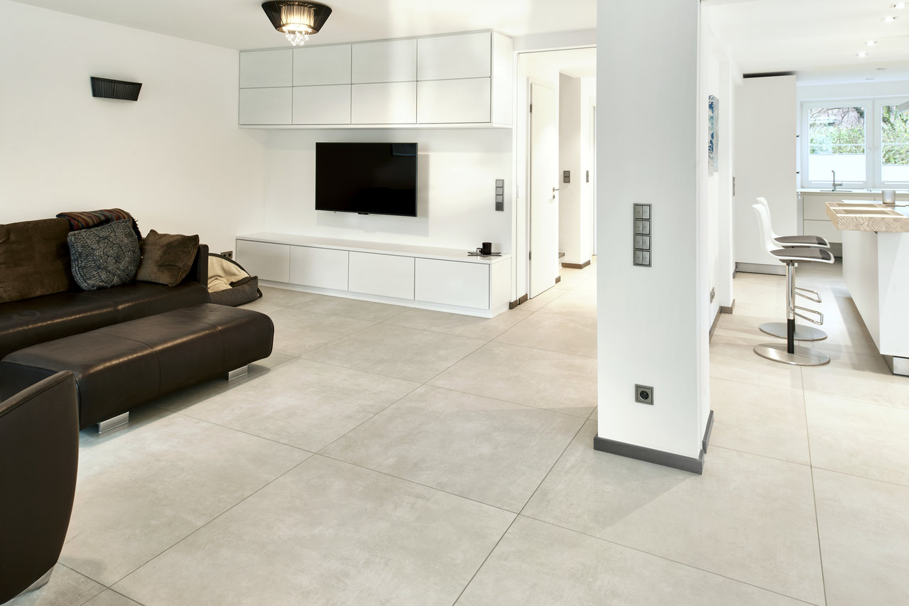 Large-format light grey tiles in a modern living and dining area.