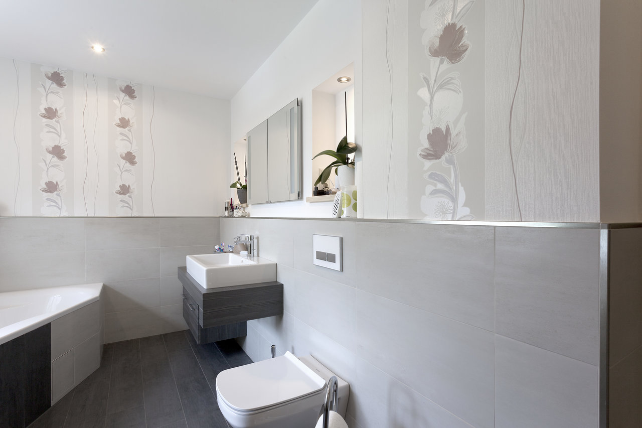 Stylish bathroom with light wall tiles and dark floor tiles.