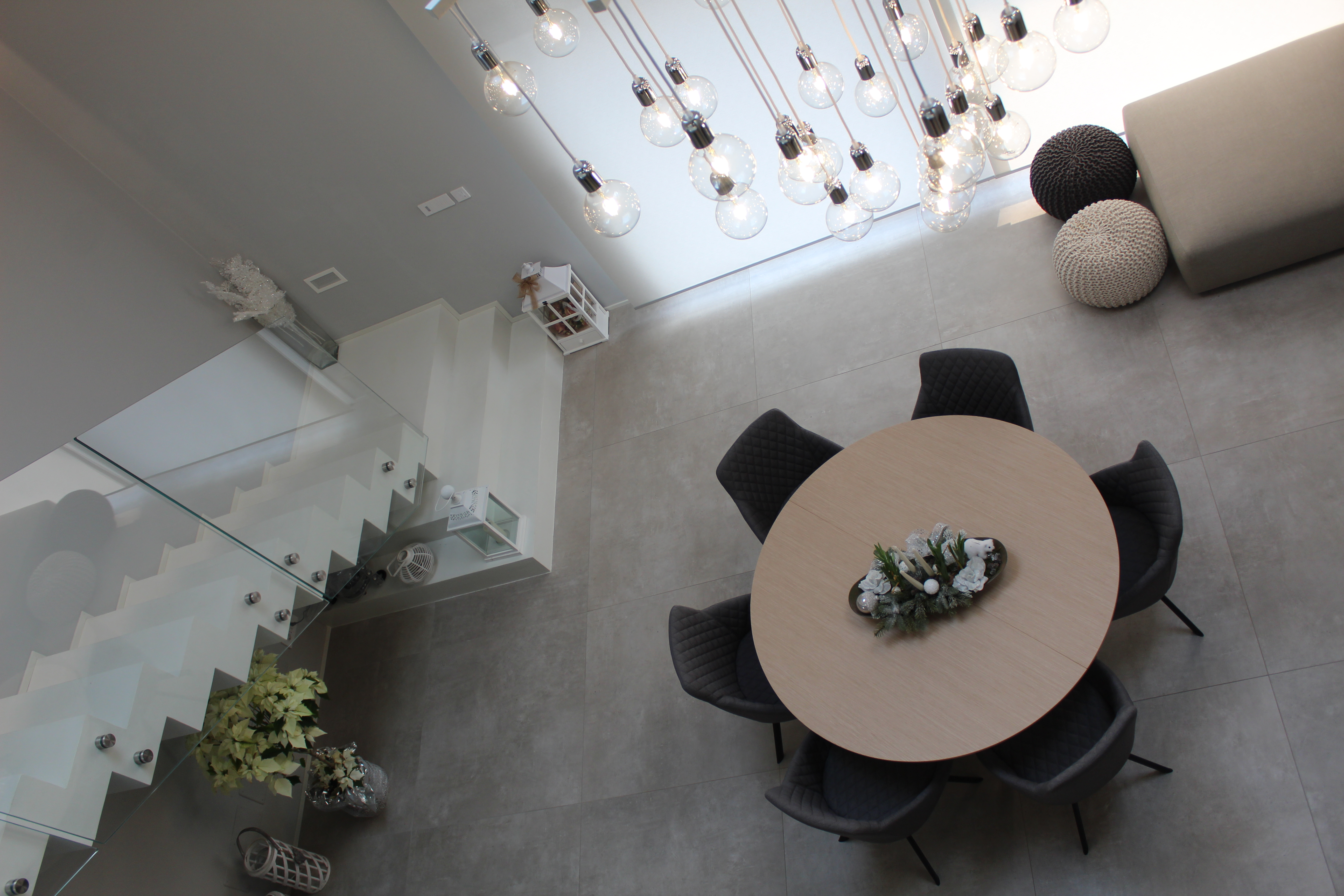 Light grey indoor tiles in a modern open-plan living and dining area with a stylish staircase.