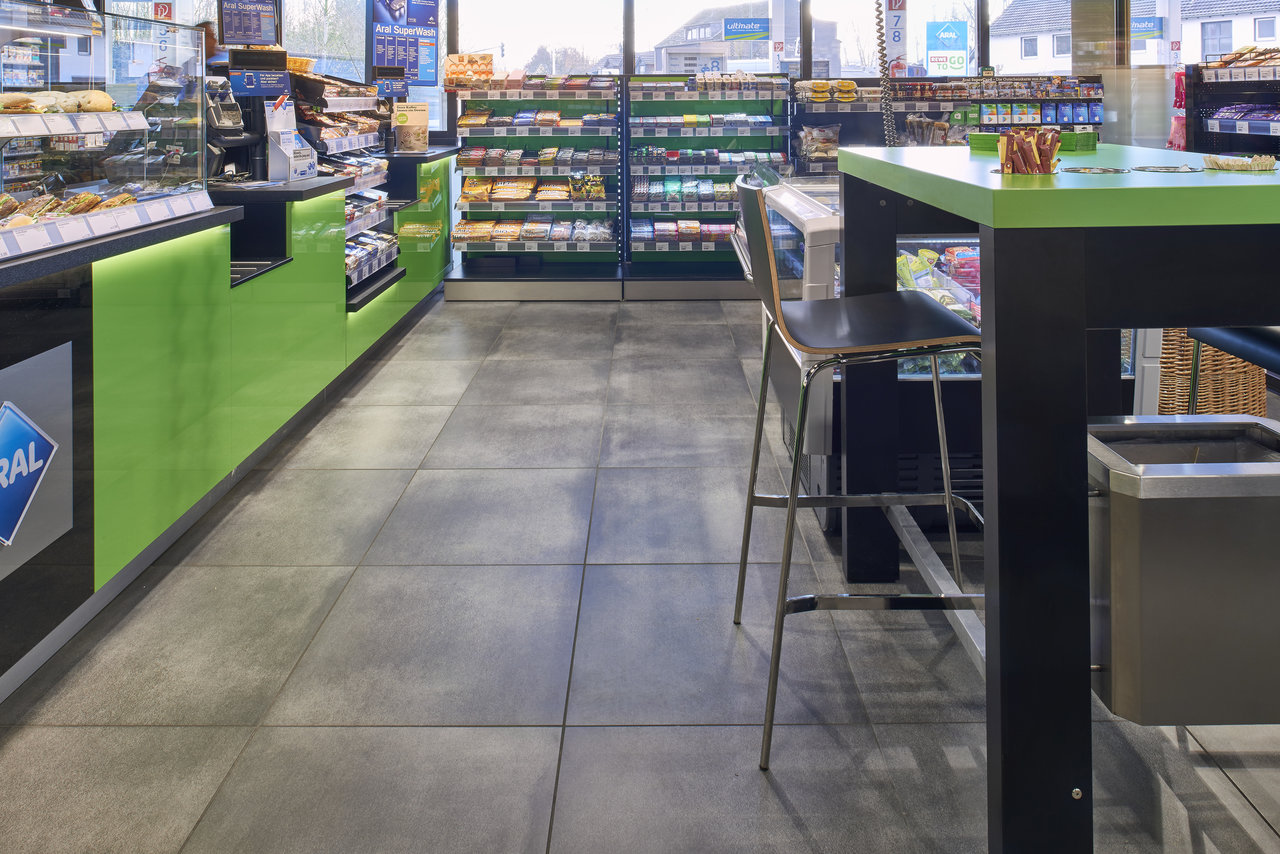 Large-format grey floor tiles in a modern shop.