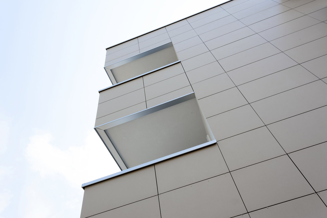 Light Porcelaingres outdoor tiles on a modern building facade with balconies.