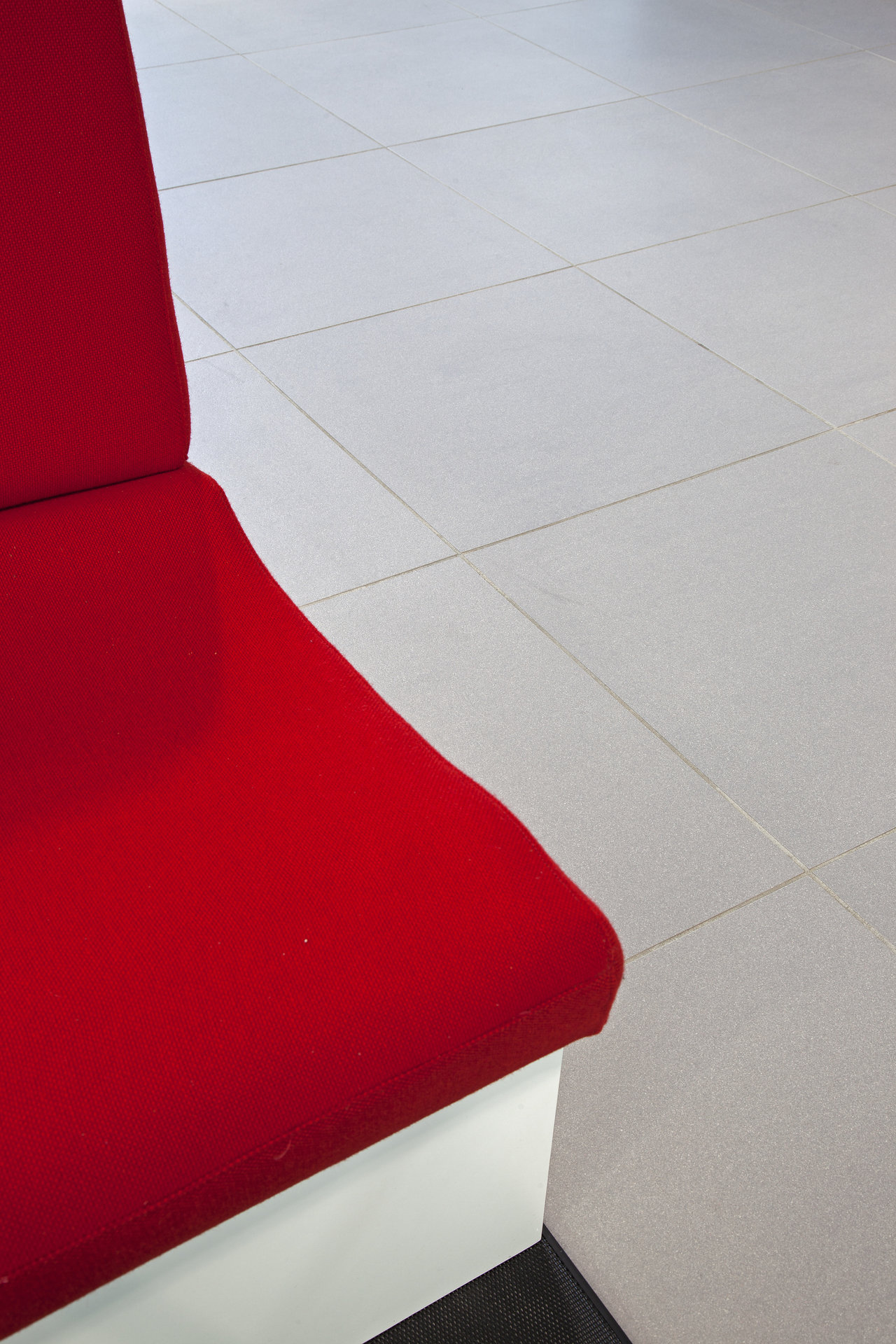 Modern, light grey tiles with red seating.