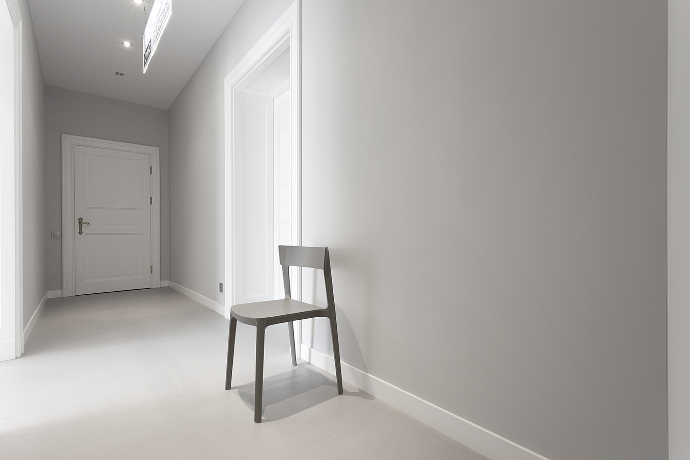 Modern hallway with light grey floor tiles and walls, ideal for Porcelaingres.