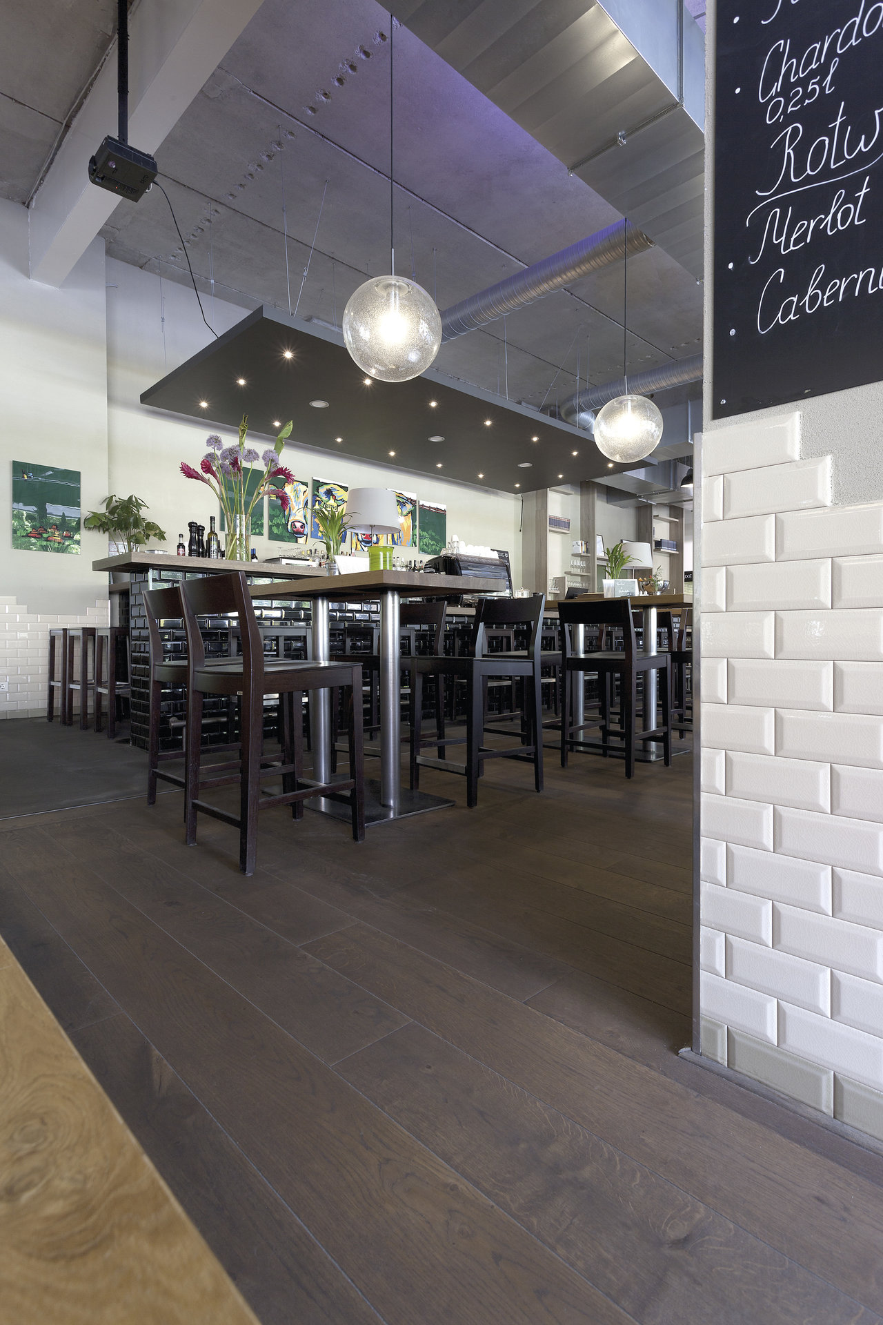 Dark wood-effect tile floor and white subway tiles in a modern hospitality area.