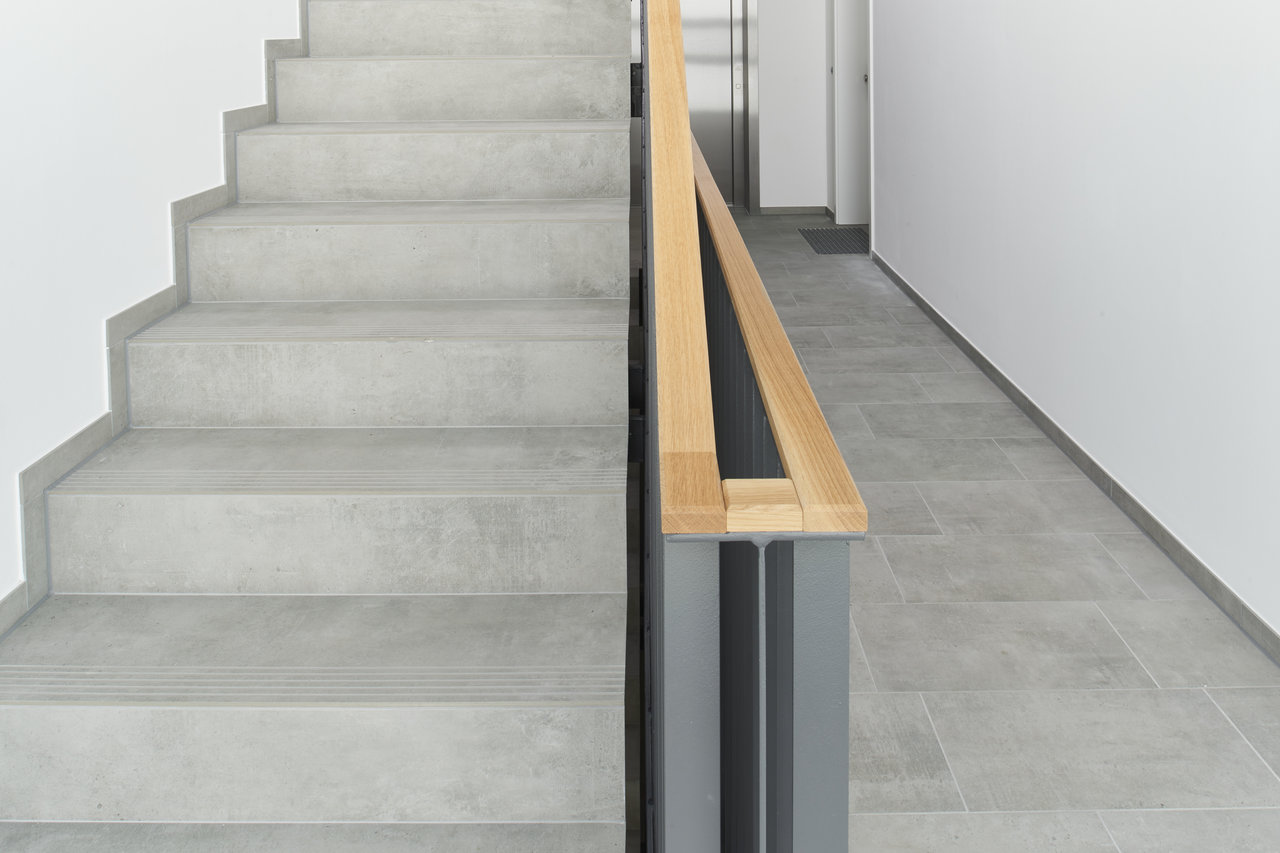 Modern stairs and hall with premium grey porcelain tiles.