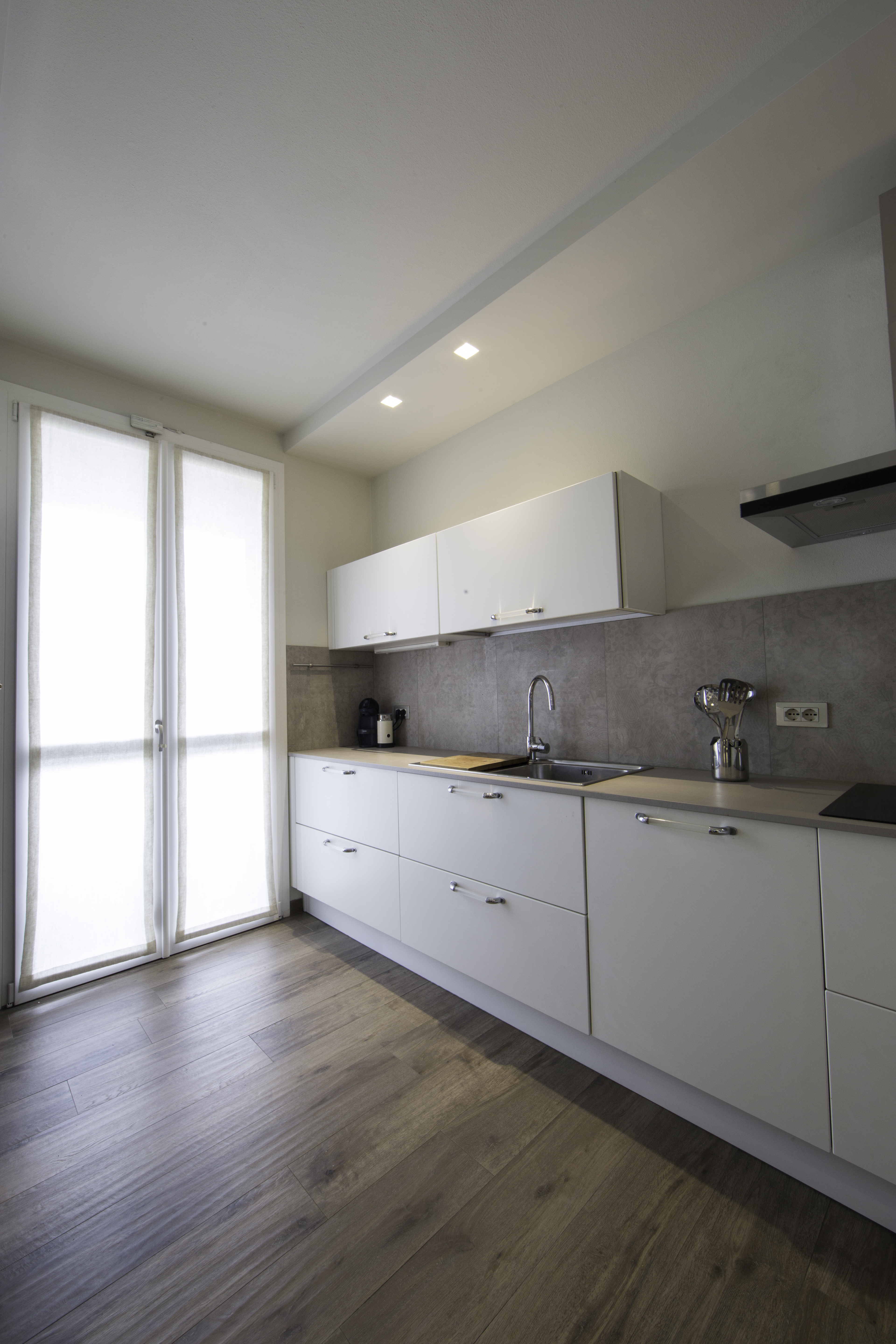 High-quality wood-effect floor tiles and grey wall tiles in a modern kitchen.