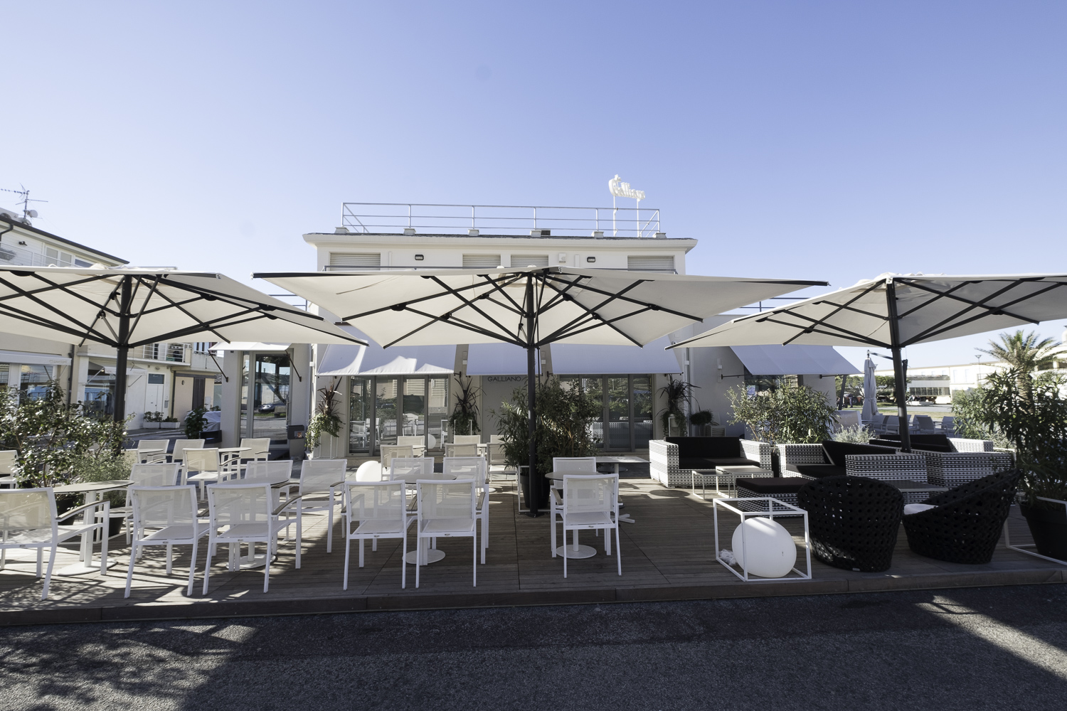 Spacious outdoor terrace with elegant outdoor tiles, modern seating, and large parasols.