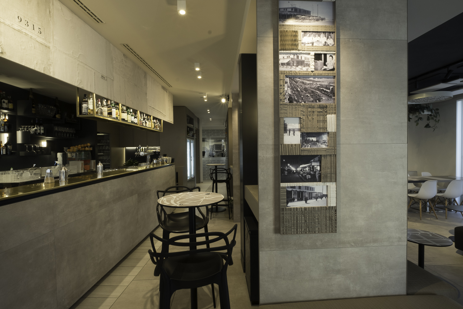 Elegant indoor café with large-format concrete-look tiles on walls and counter.
