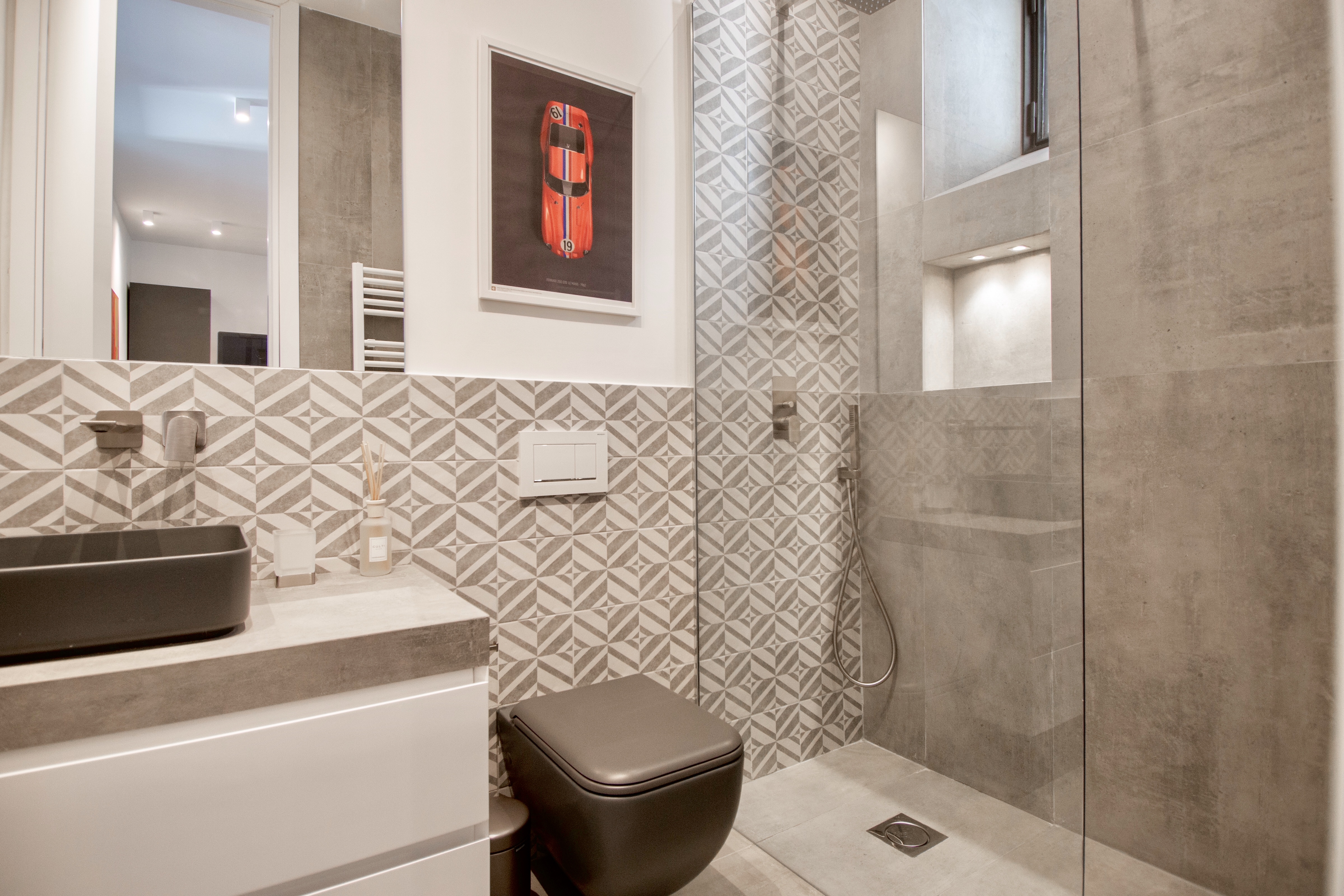 Modern bathroom with stylish grey and patterned tiles.