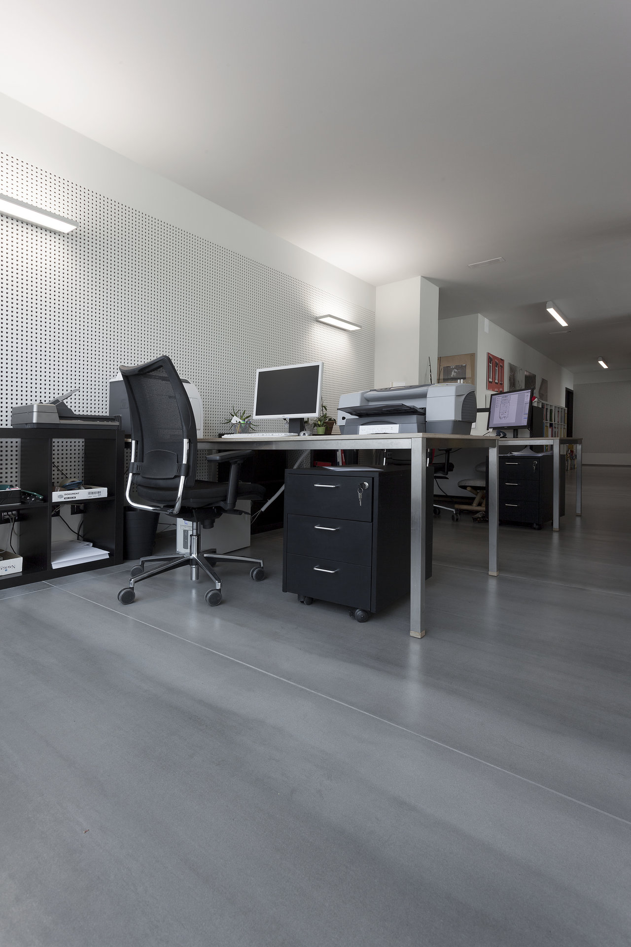 Modern office with elegant, light grey concrete-look tiled floor.