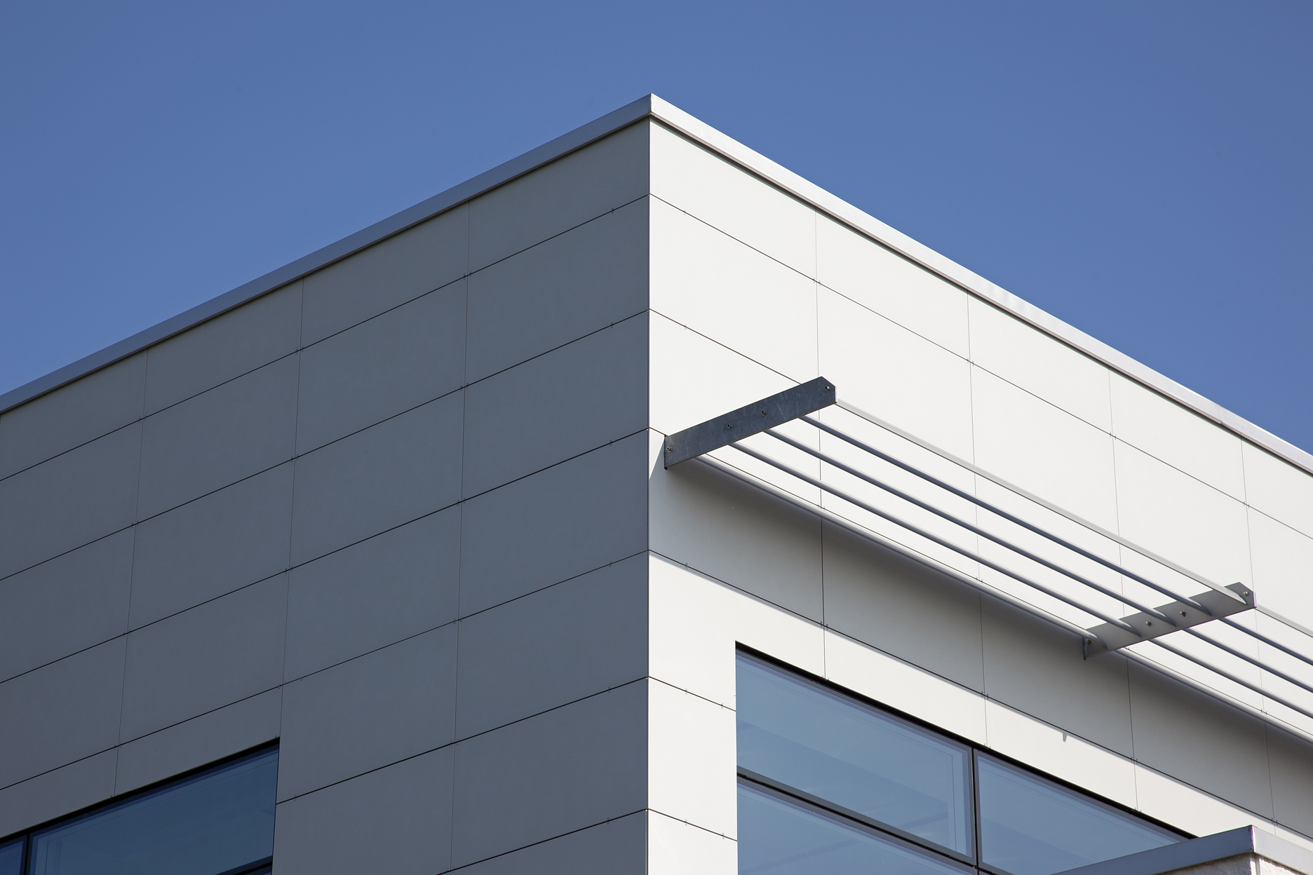 Elegant building facade with bright, large-format tiles and clean lines.