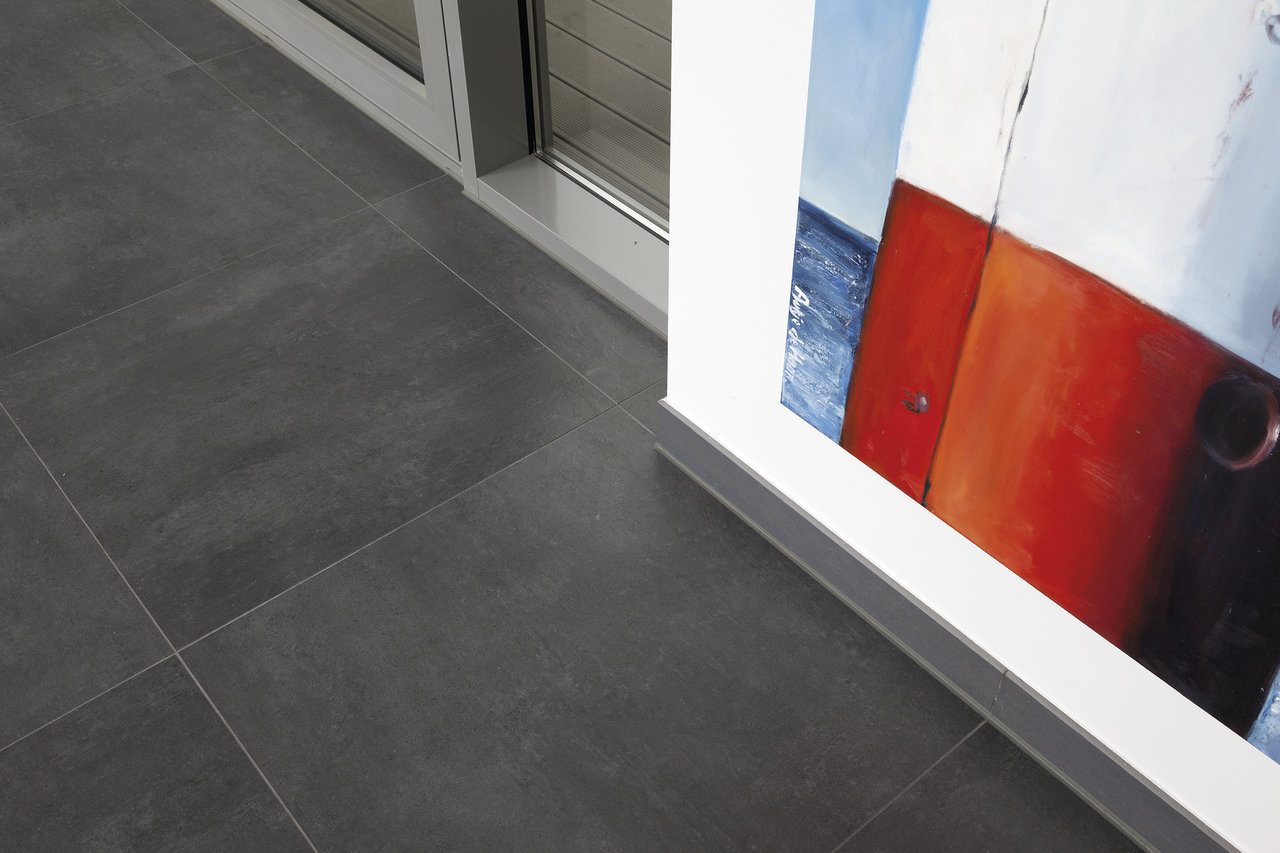 Dark grey concrete effect indoor floor tiles.