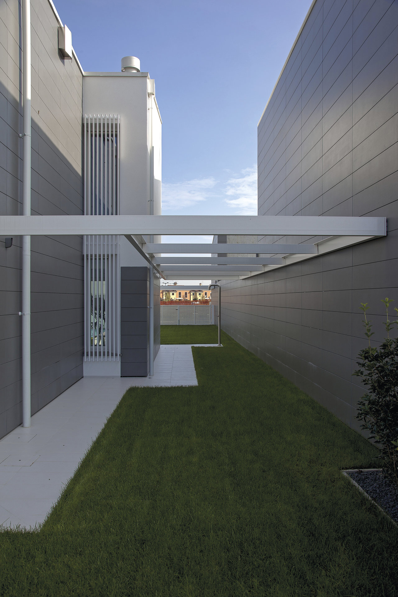 Contemporary building with grey tile cladding and a light outdoor path.