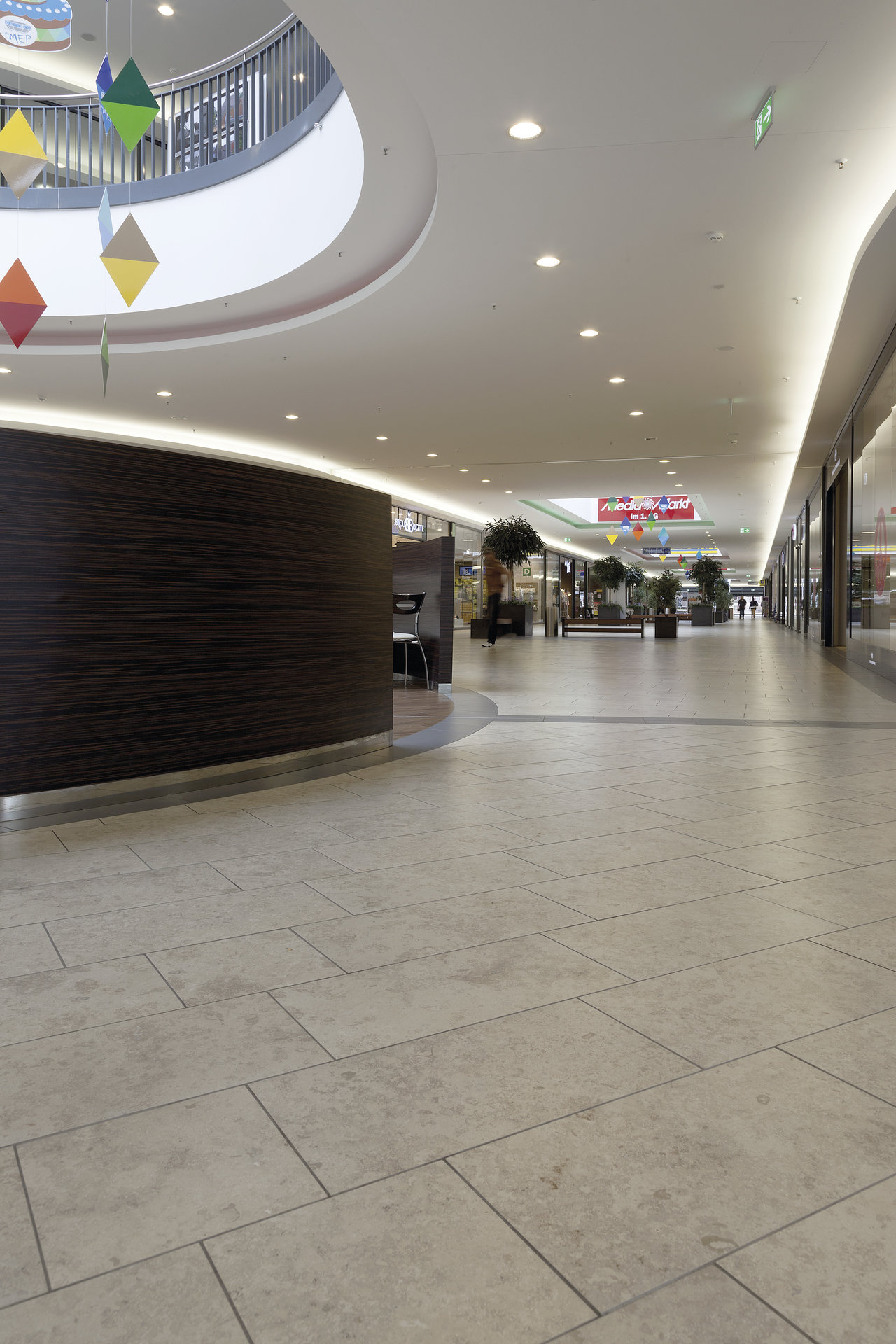 Light tiled flooring in a modern shopping centre, ideal for high-traffic areas.