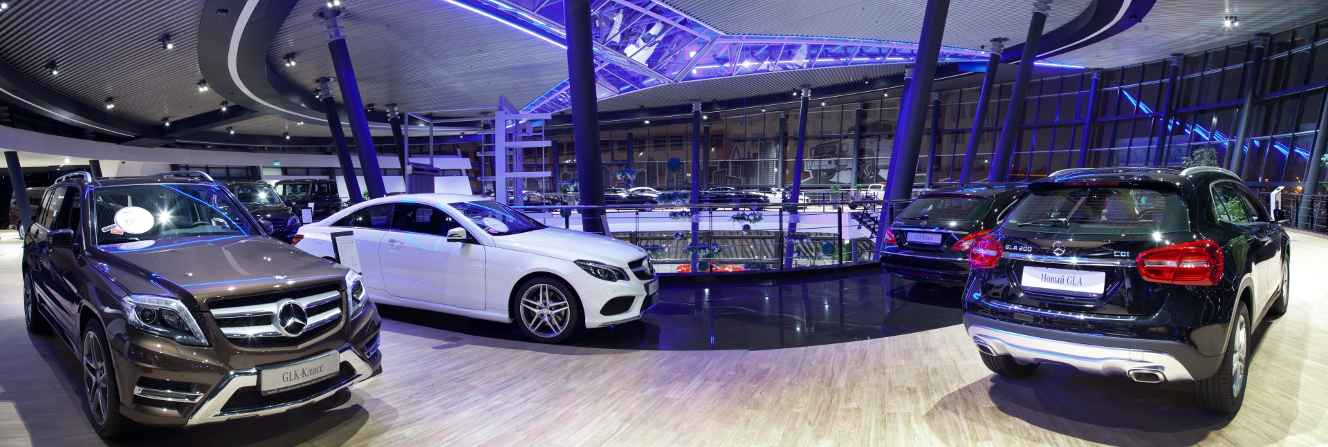 Mercedes-Benz dealership with cars and blue accent lighting.