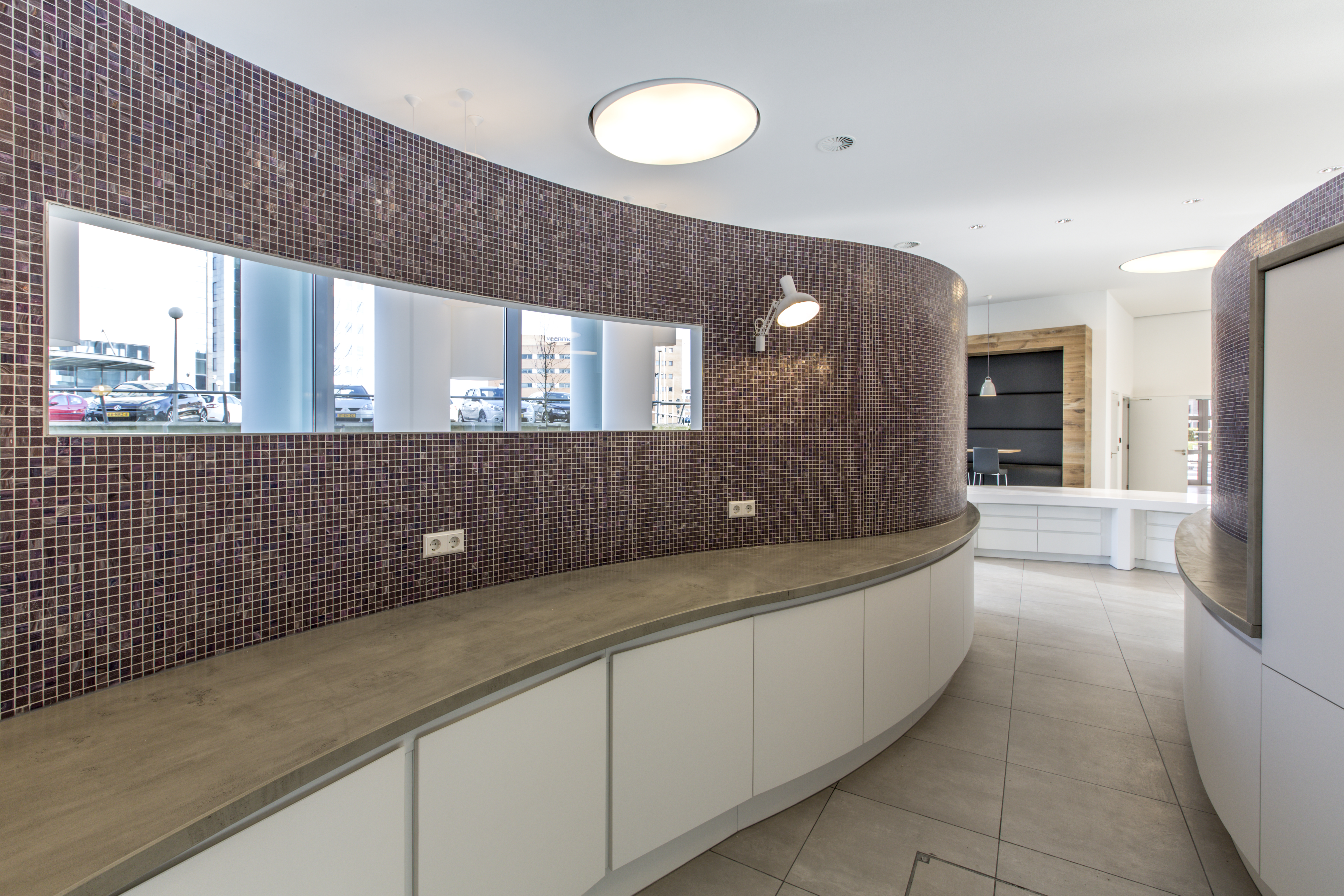High-quality mosaic tiles on a curved wall in a stylish reception area.