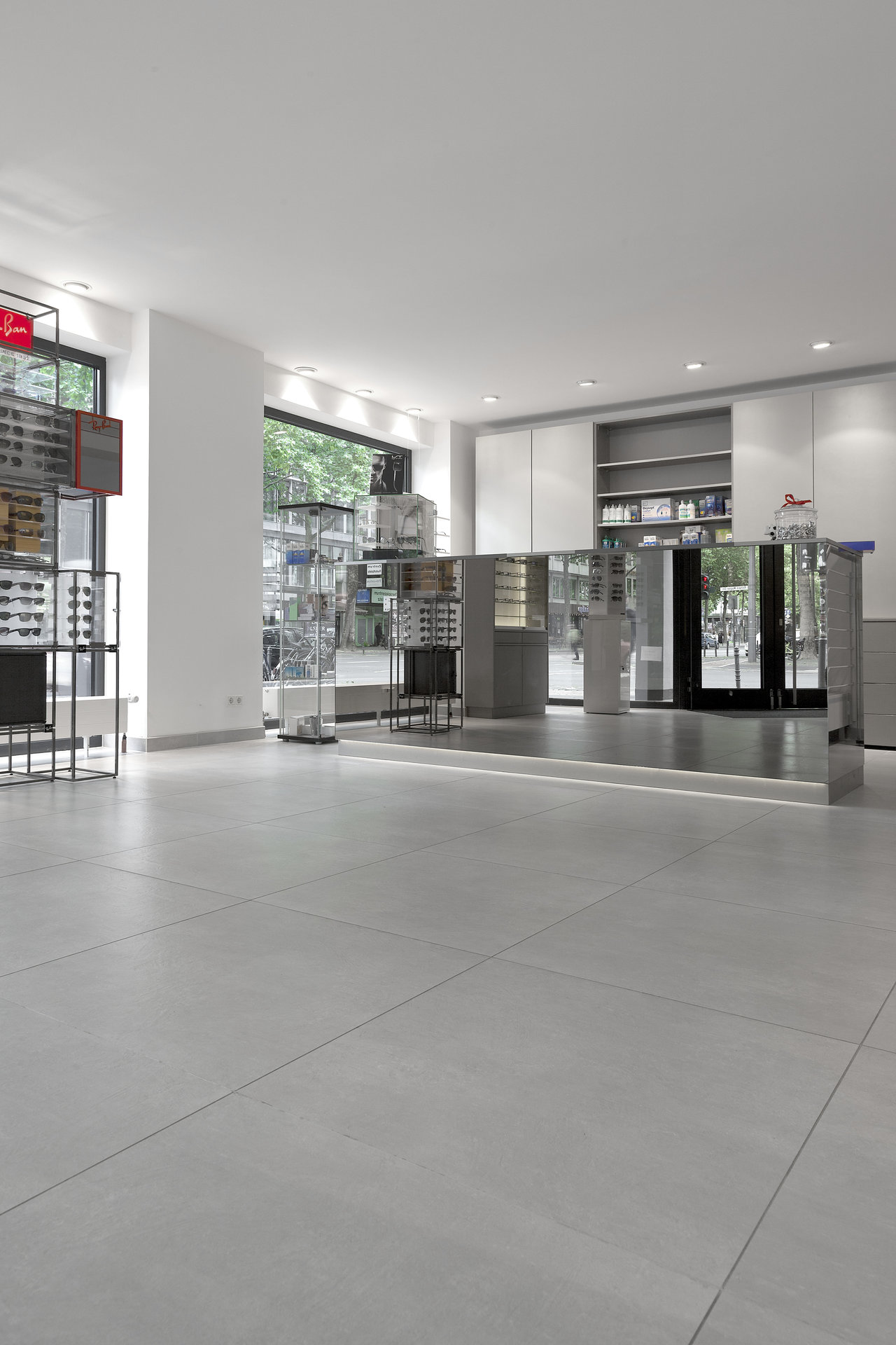 Large-format, light grey floor tiles in a modern shop.