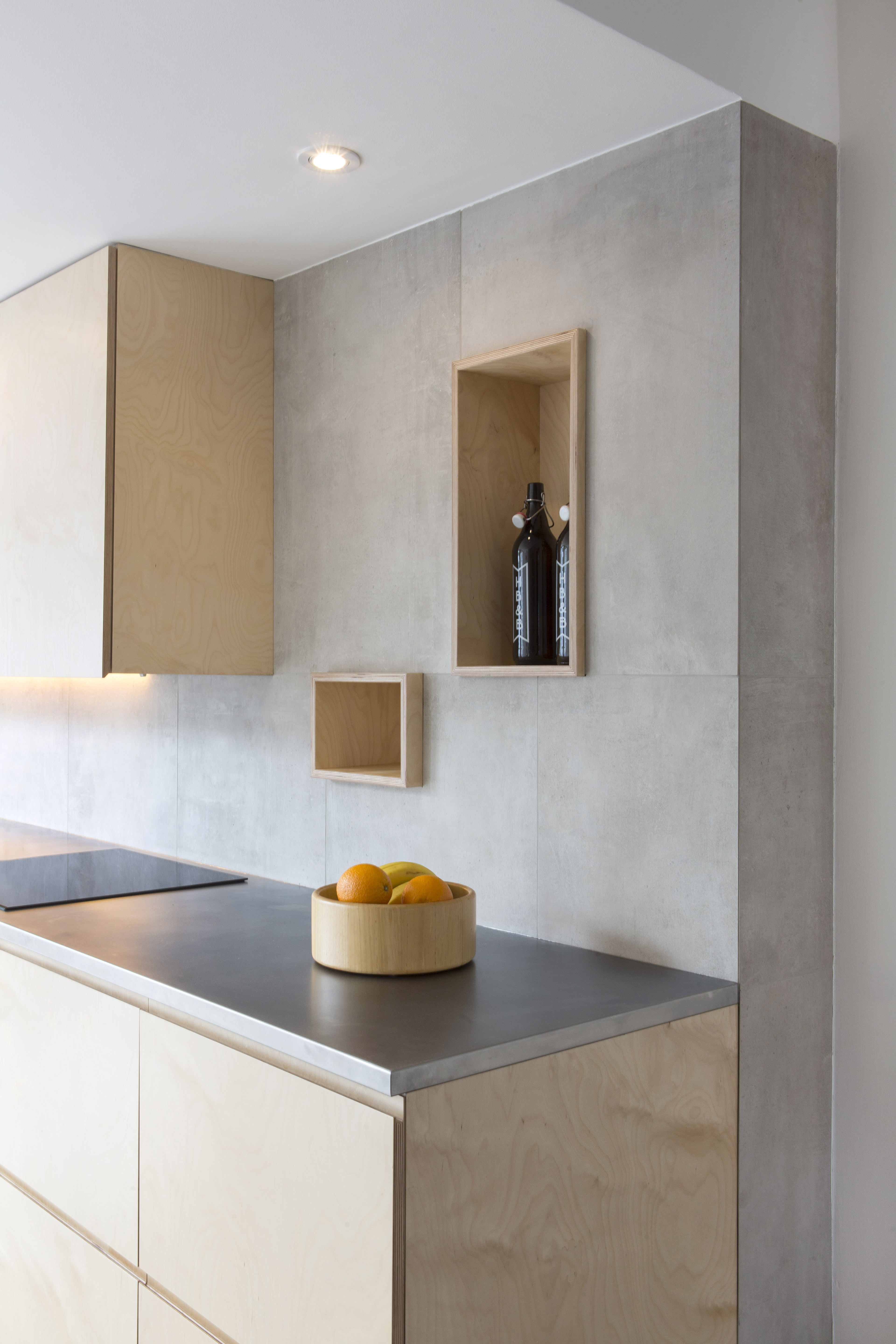 Bright kitchen with large-format concrete-effect wall tiles.