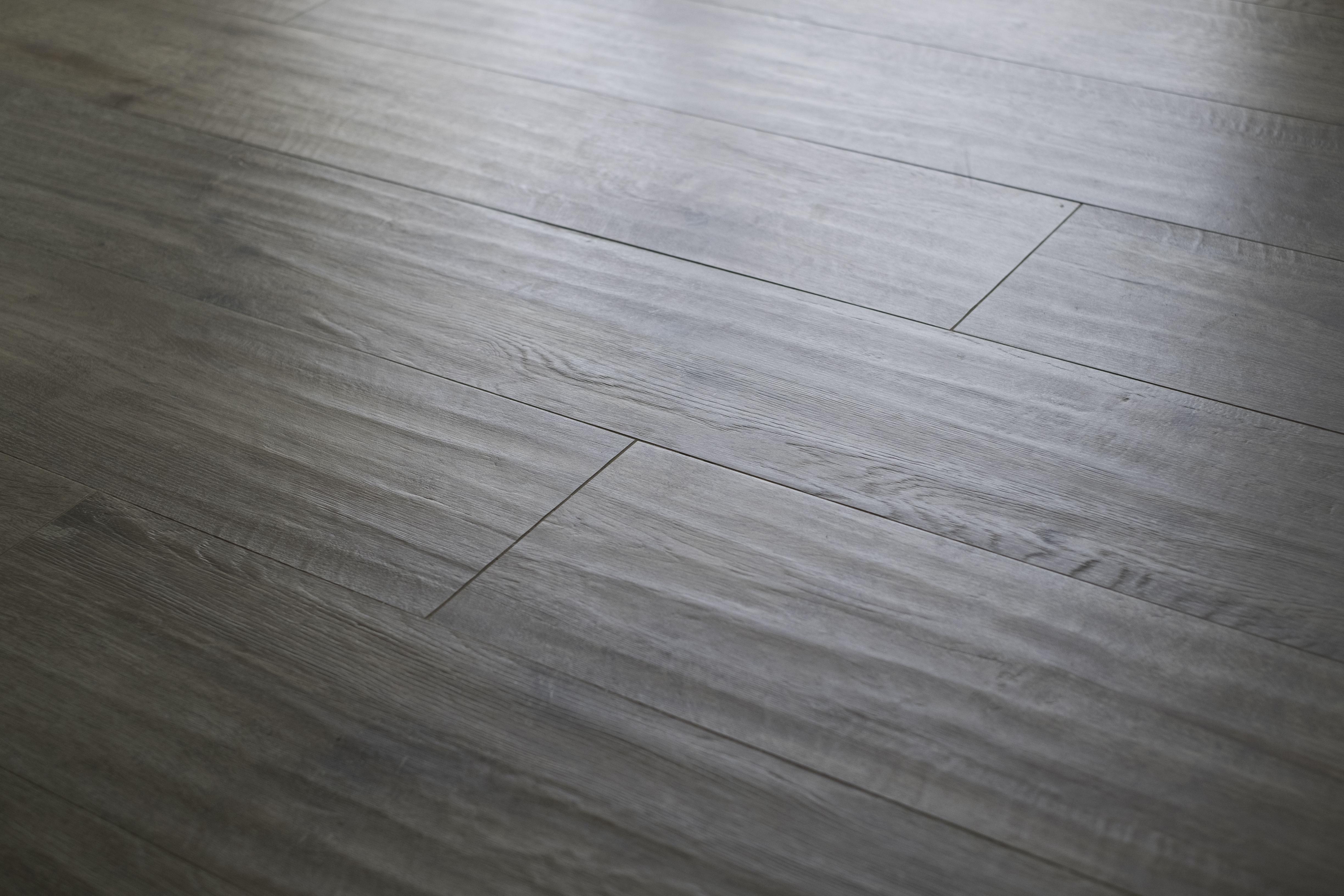 Dark grey wood-look tiles with fine grain for modern living spaces.