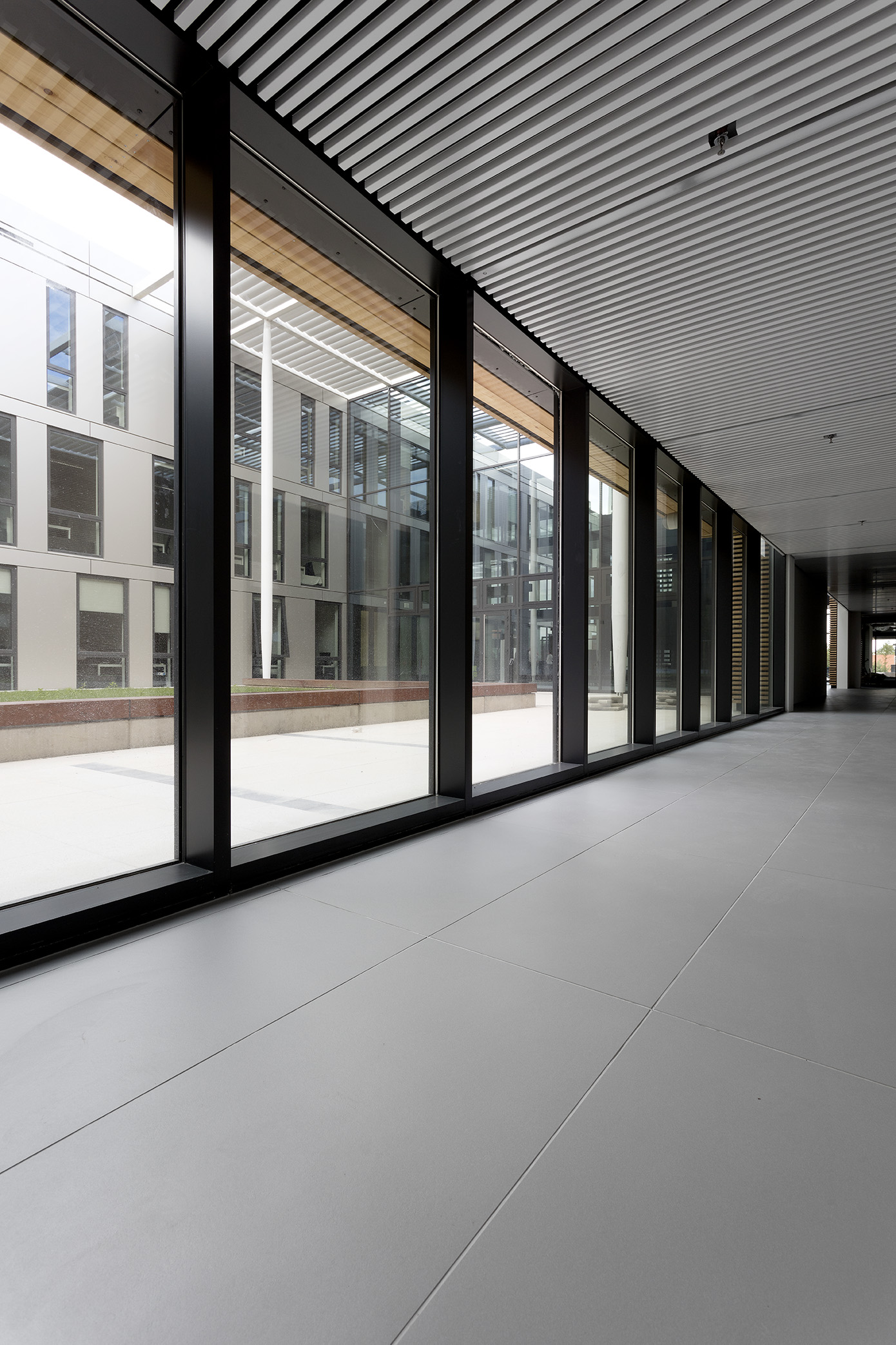 High-quality, large-format light grey indoor tiles in a modern hallway.