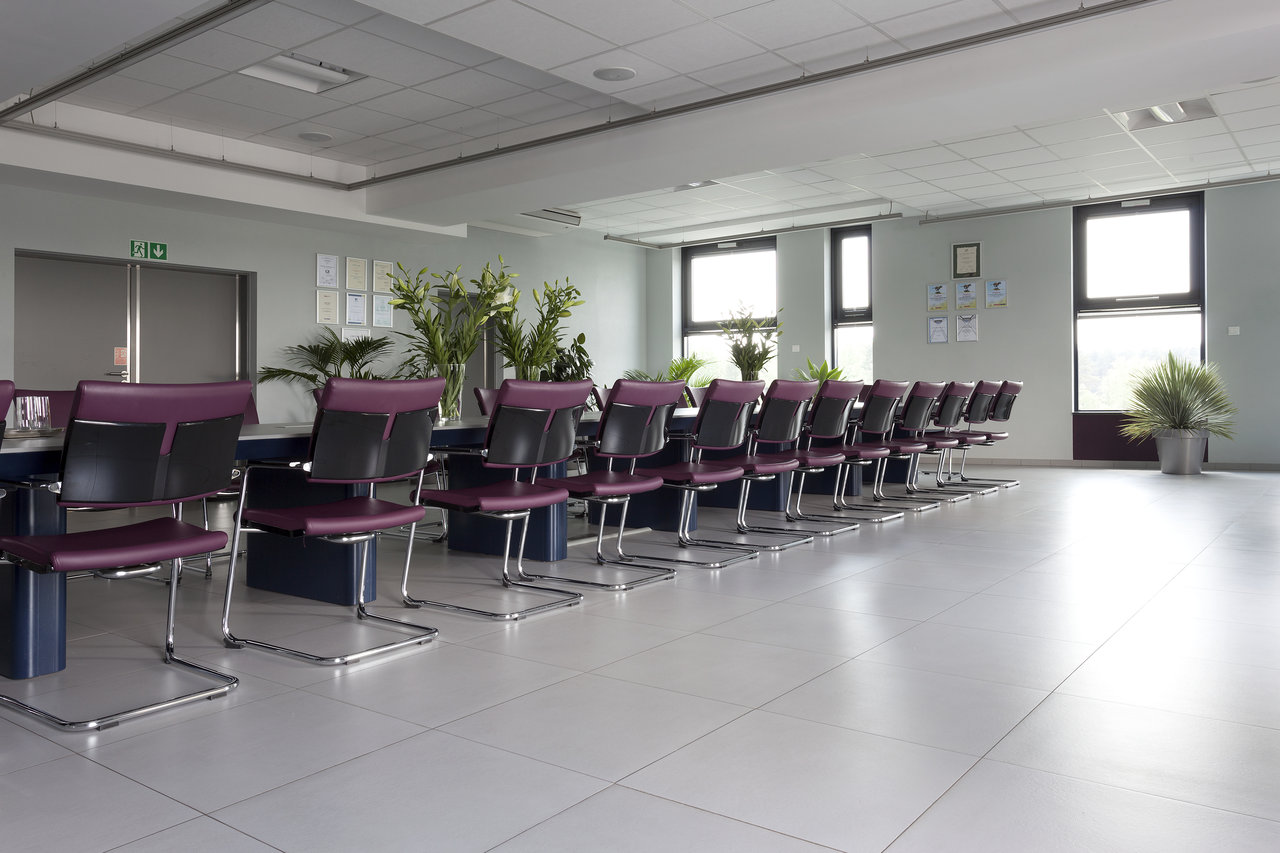 Modern meeting room with bright, large-format floor tiles.