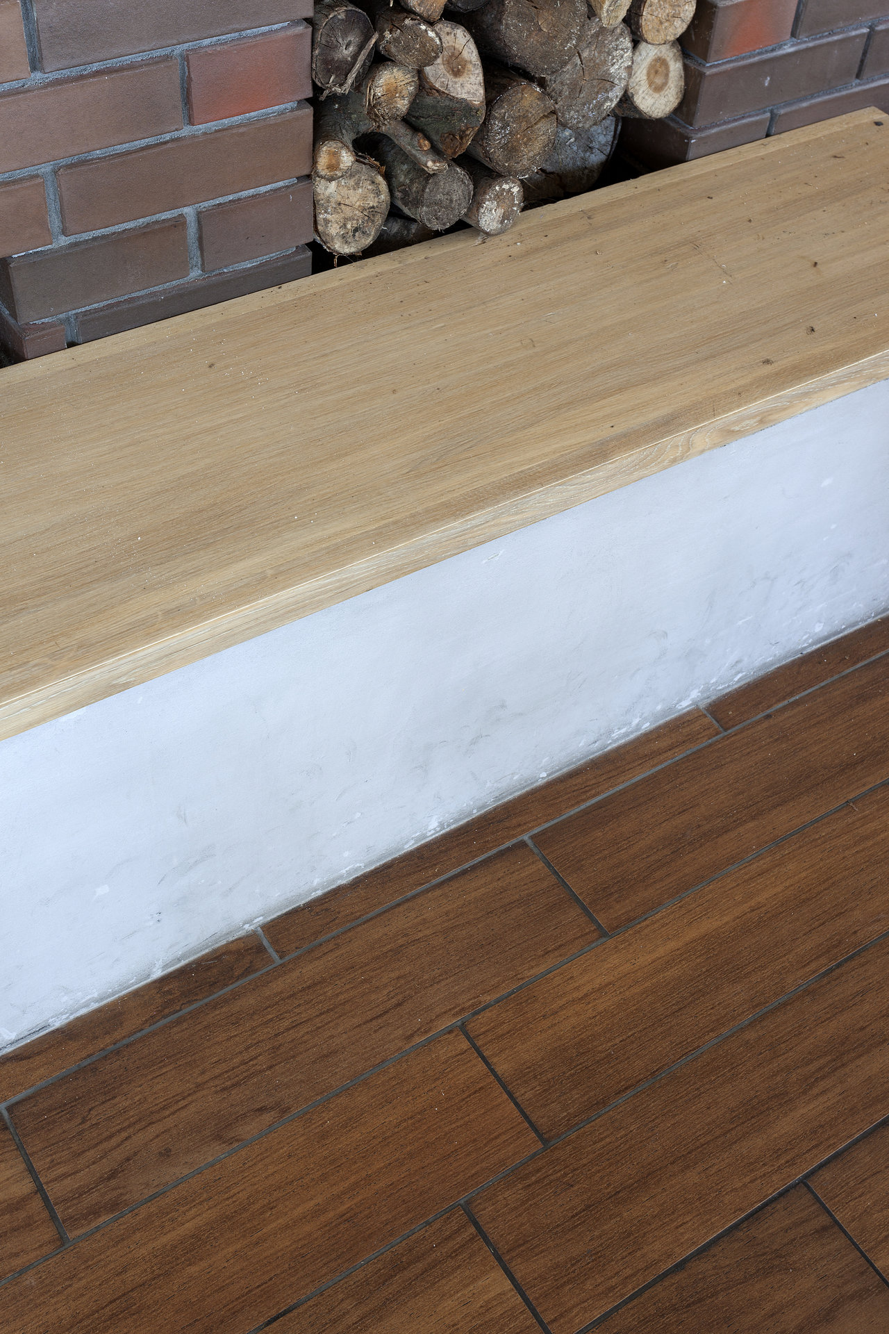 High-quality dark wood-effect floor tiles by a fireplace.