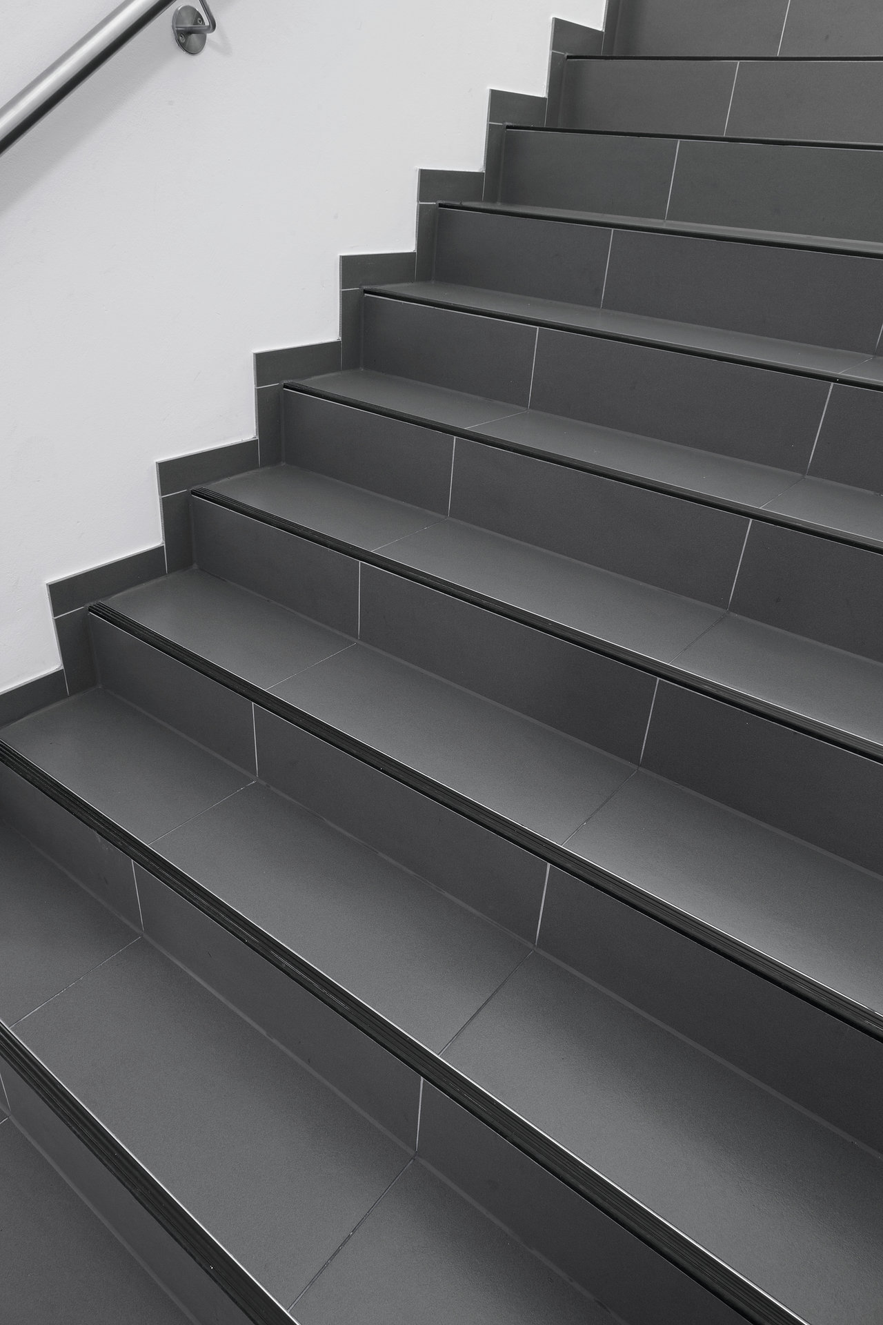 Modern staircase featuring premium dark grey indoor/outdoor tiles.