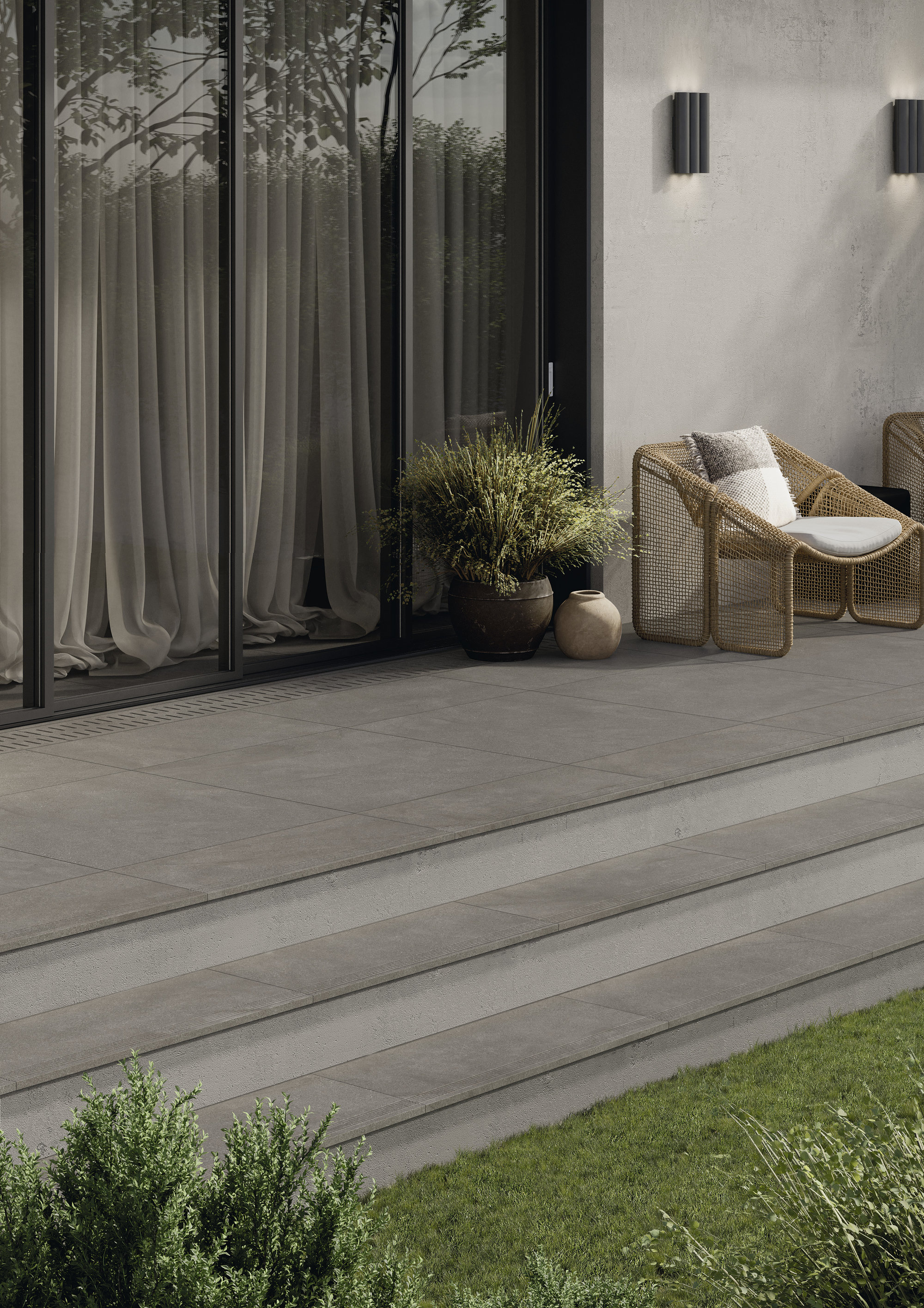 High-quality grey outdoor tiles on a modern terrace with steps leading to the garden.