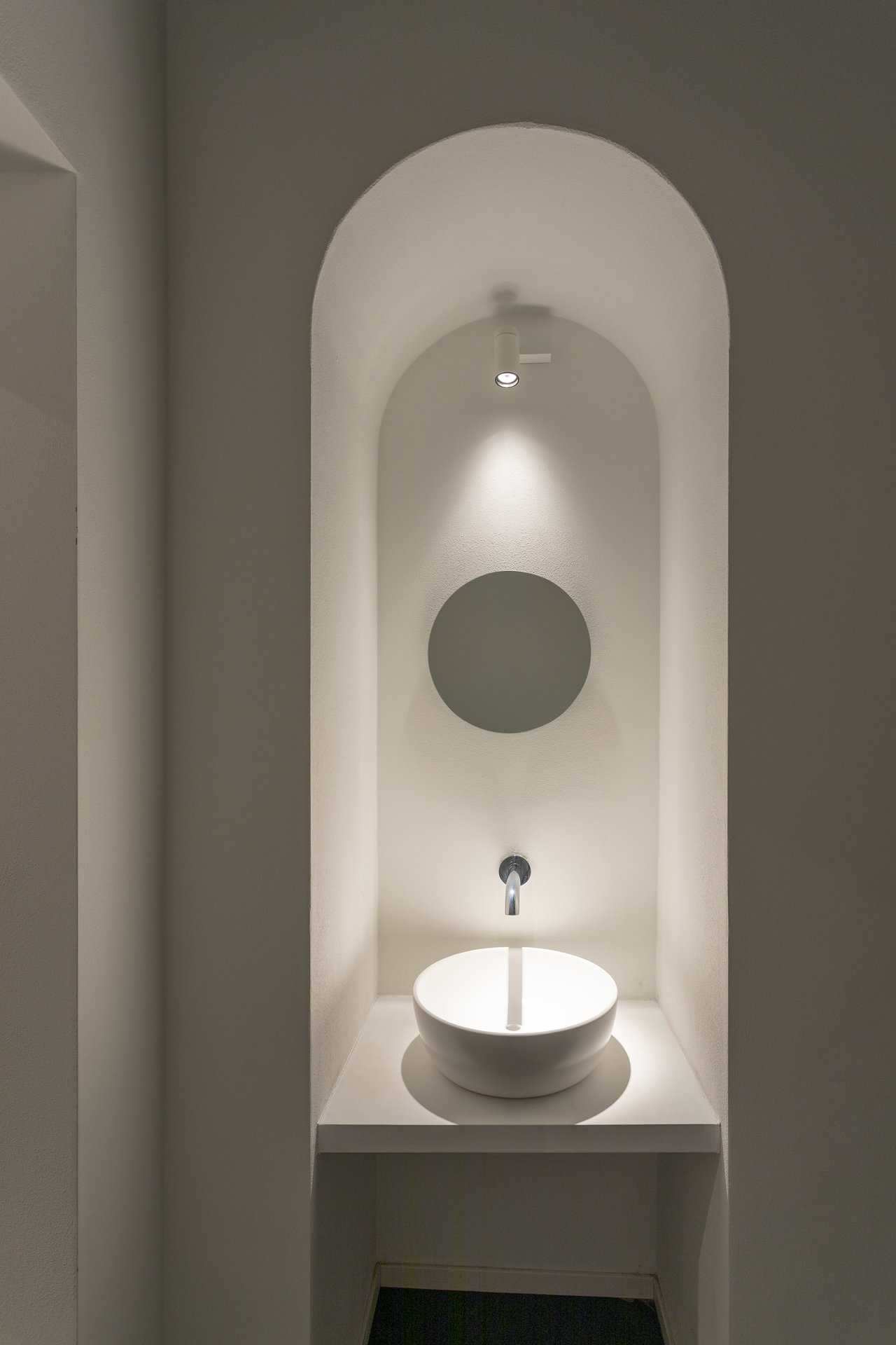Minimalist Bathroom Design: Round Basin in Illuminated Niche with Mirror.