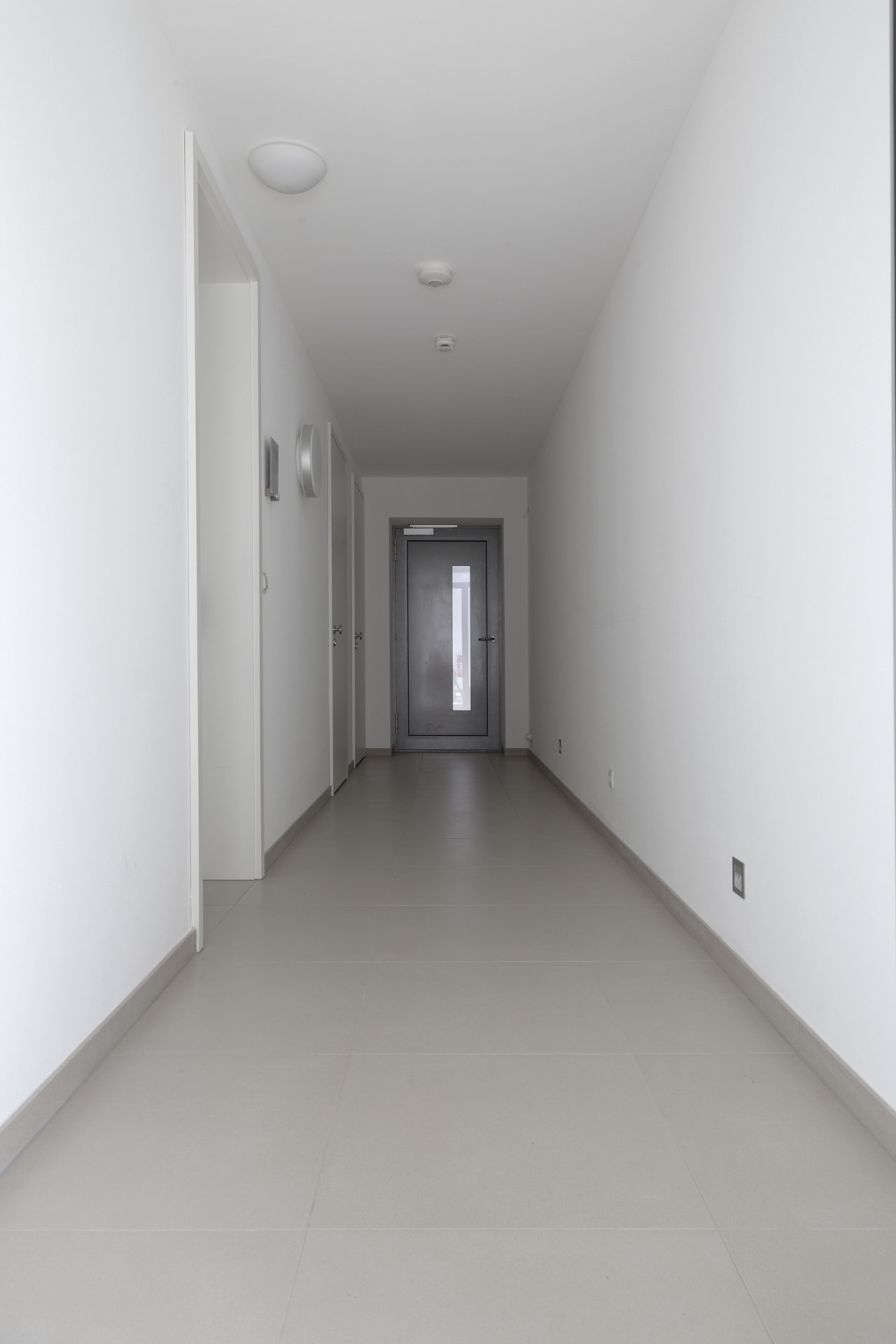 Bright hallway with modern, light grey floor tiles.