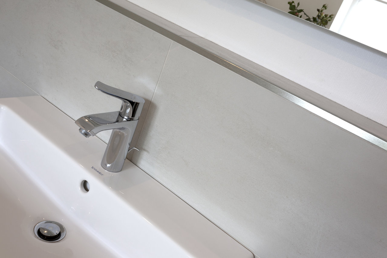Bright, modern wall tiles behind a bathroom sink.