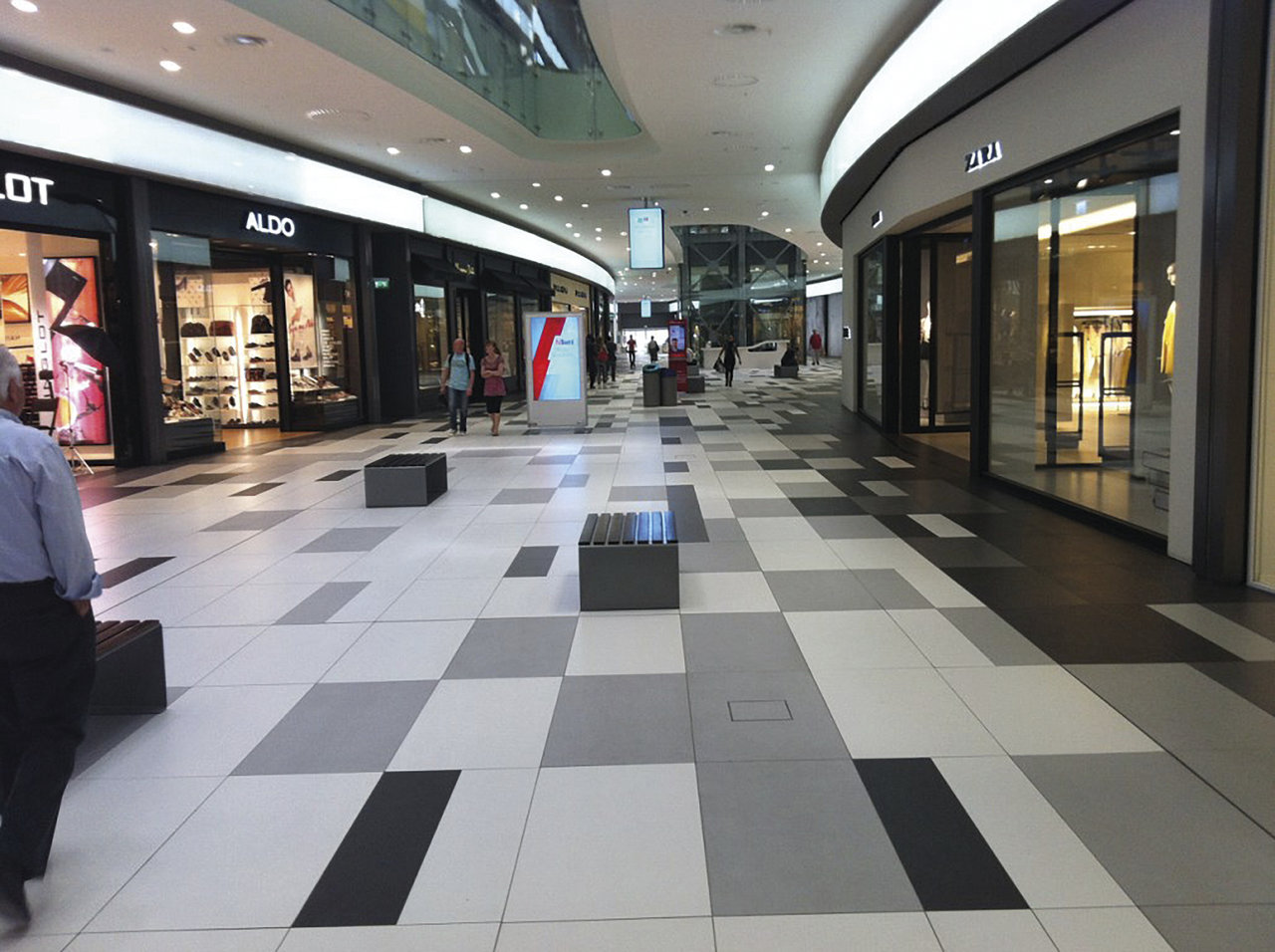 Geometric grey, white & black tile flooring in a modern shopping centre.