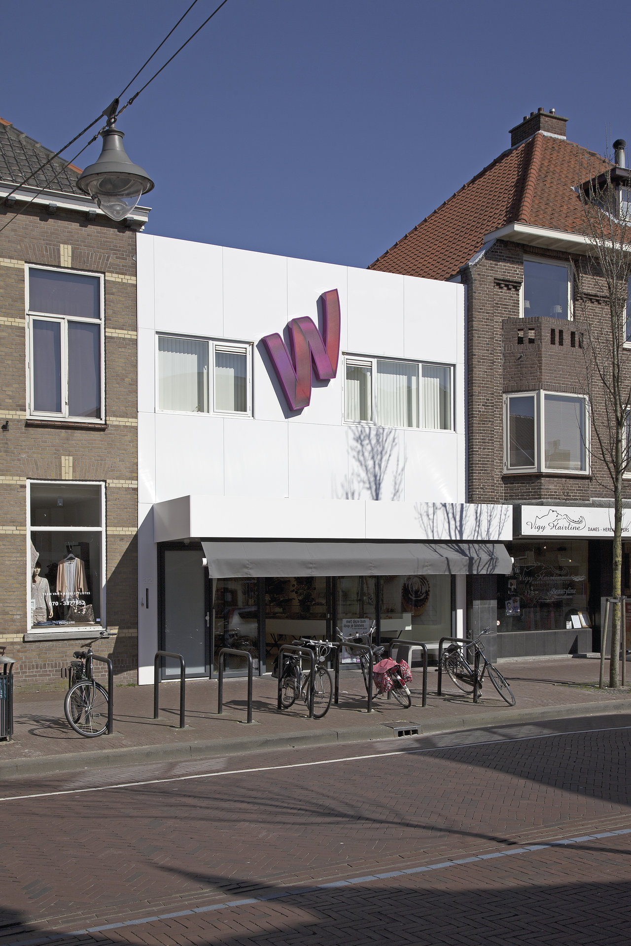 Facade of a modern building with the purple 'W' logo of Schöner Wohnen.