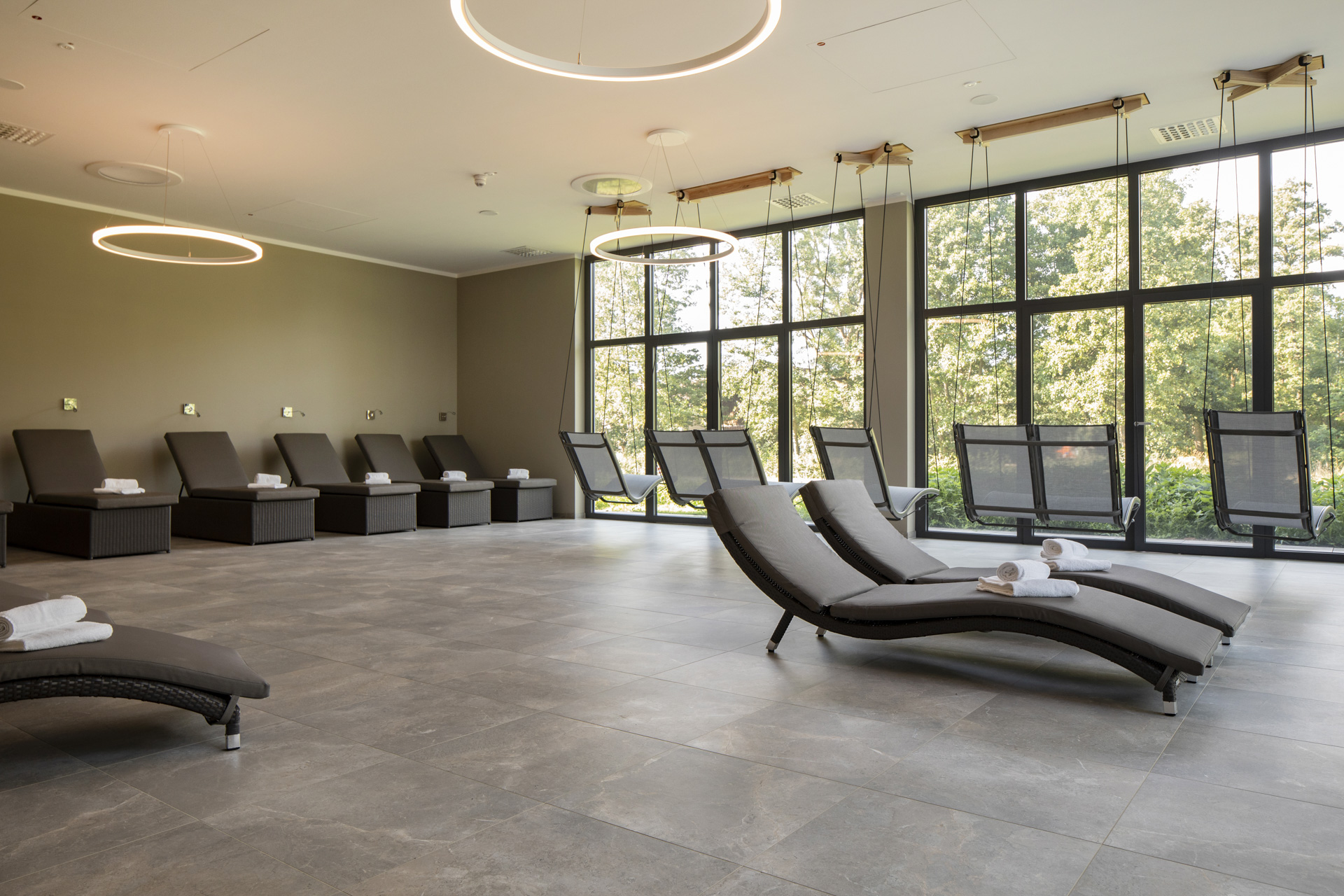 Elegant spa area with large-format grey floor tiles and loungers.