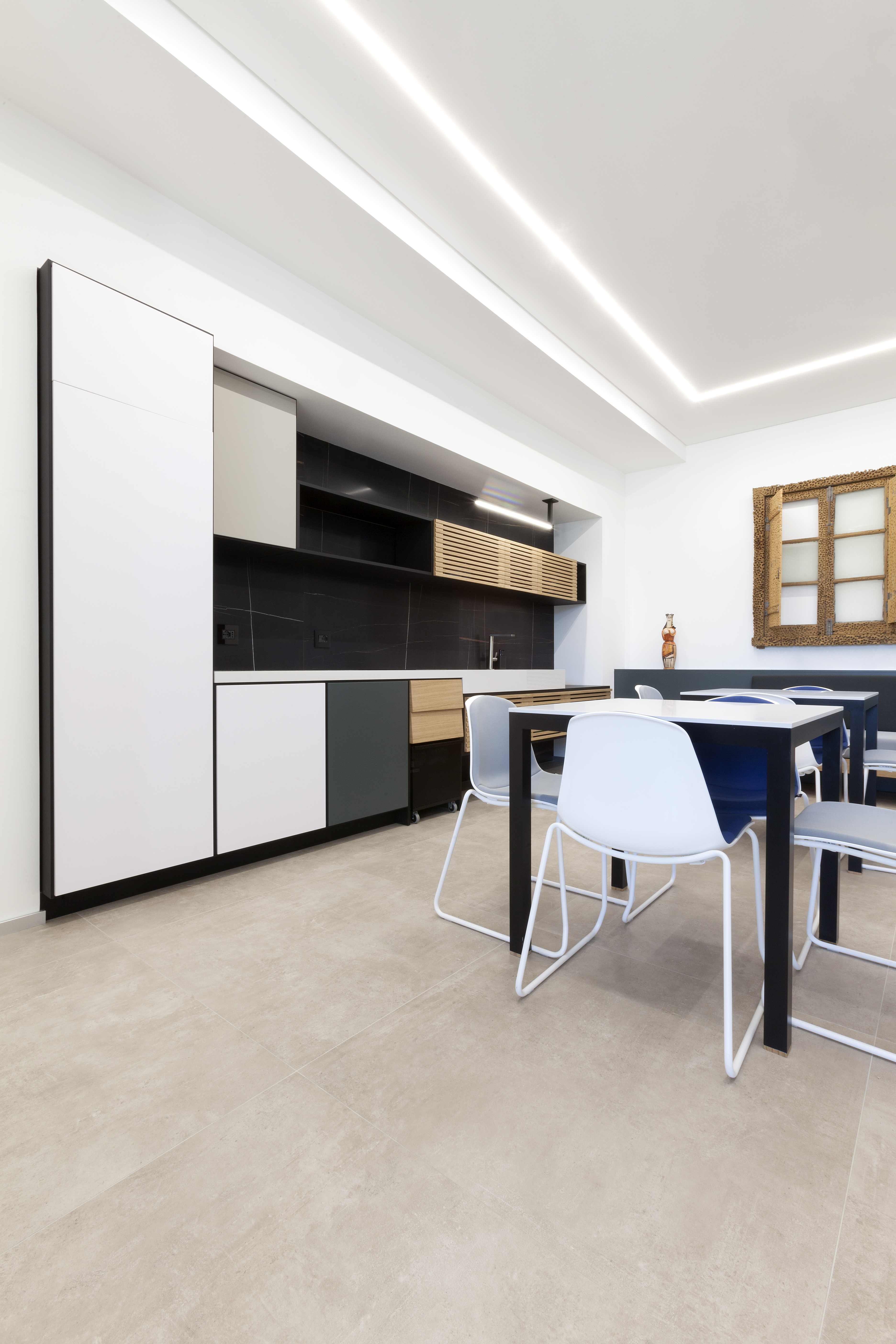 Light, large-format floor tiles in a modern kitchen-diner.