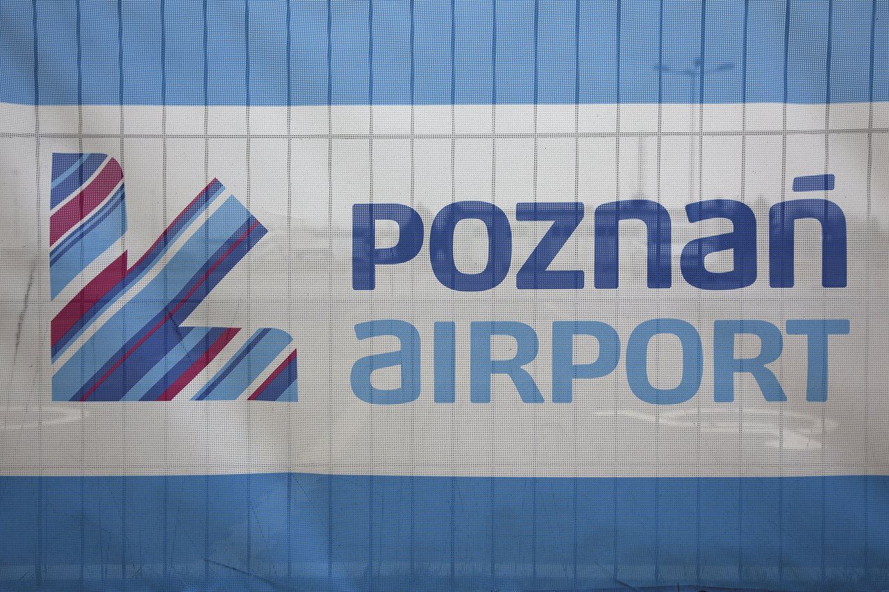 Poznań Airport logo and wordmark on a banner.