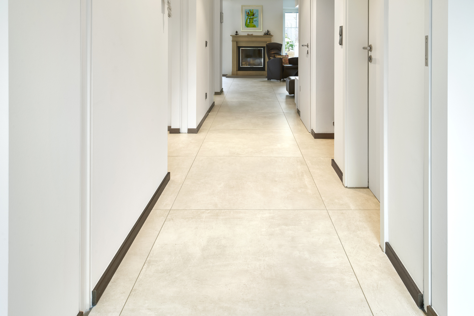 Spacious hallway with bright porcelain tiles leading to a cosy living area.