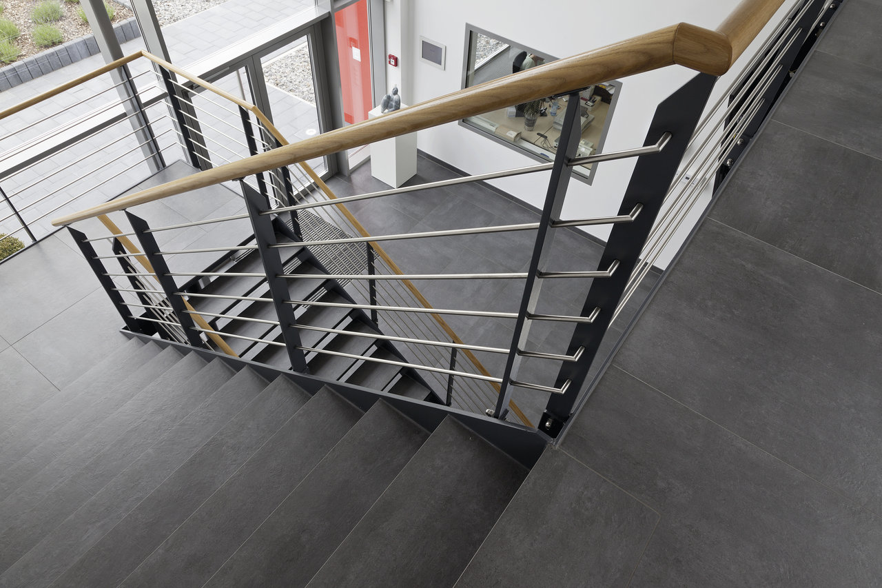 High-quality anthracite stair tiles, combined with a modern wood and stainless steel railing.