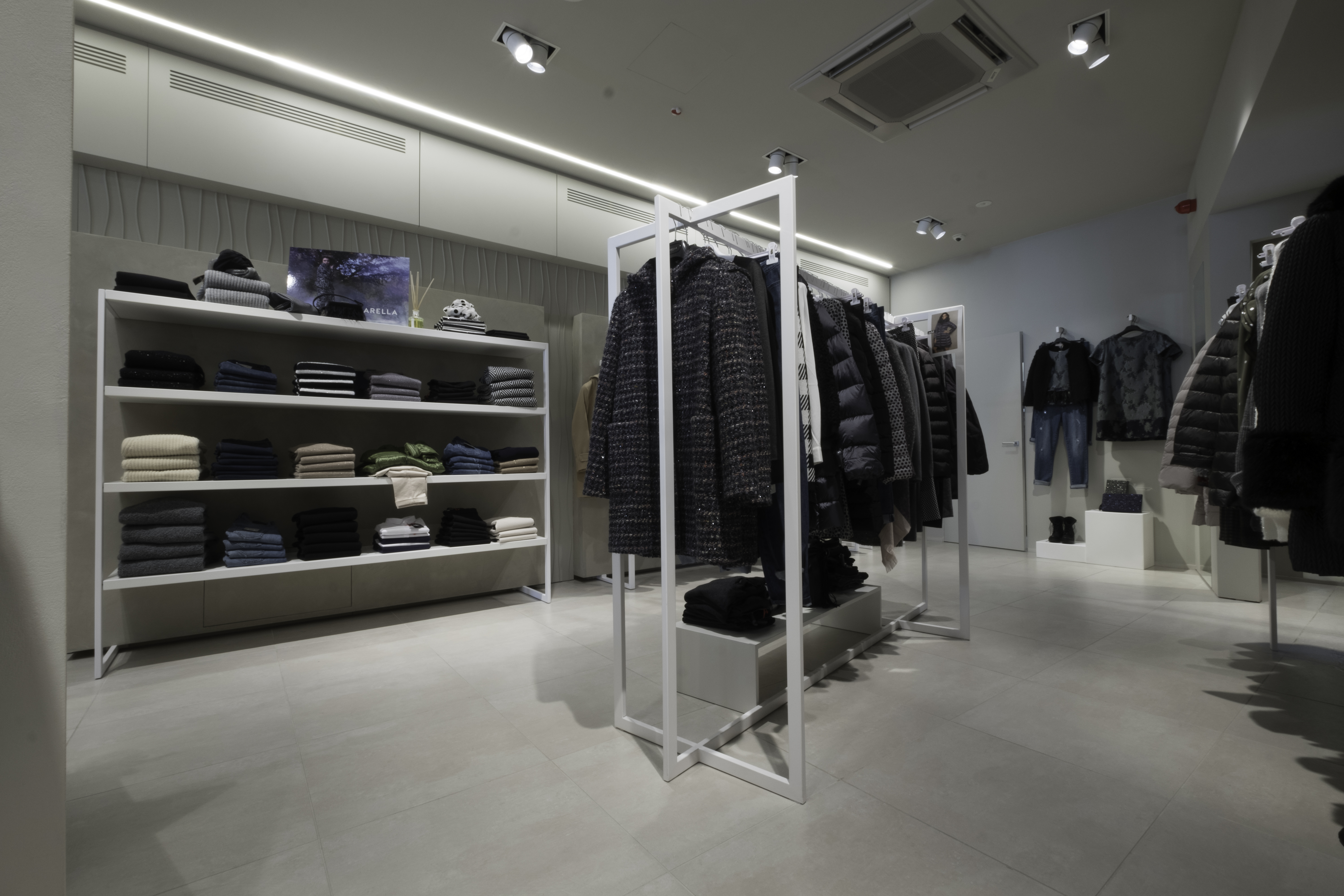 Interior of a modern clothing store with light grey flooring.