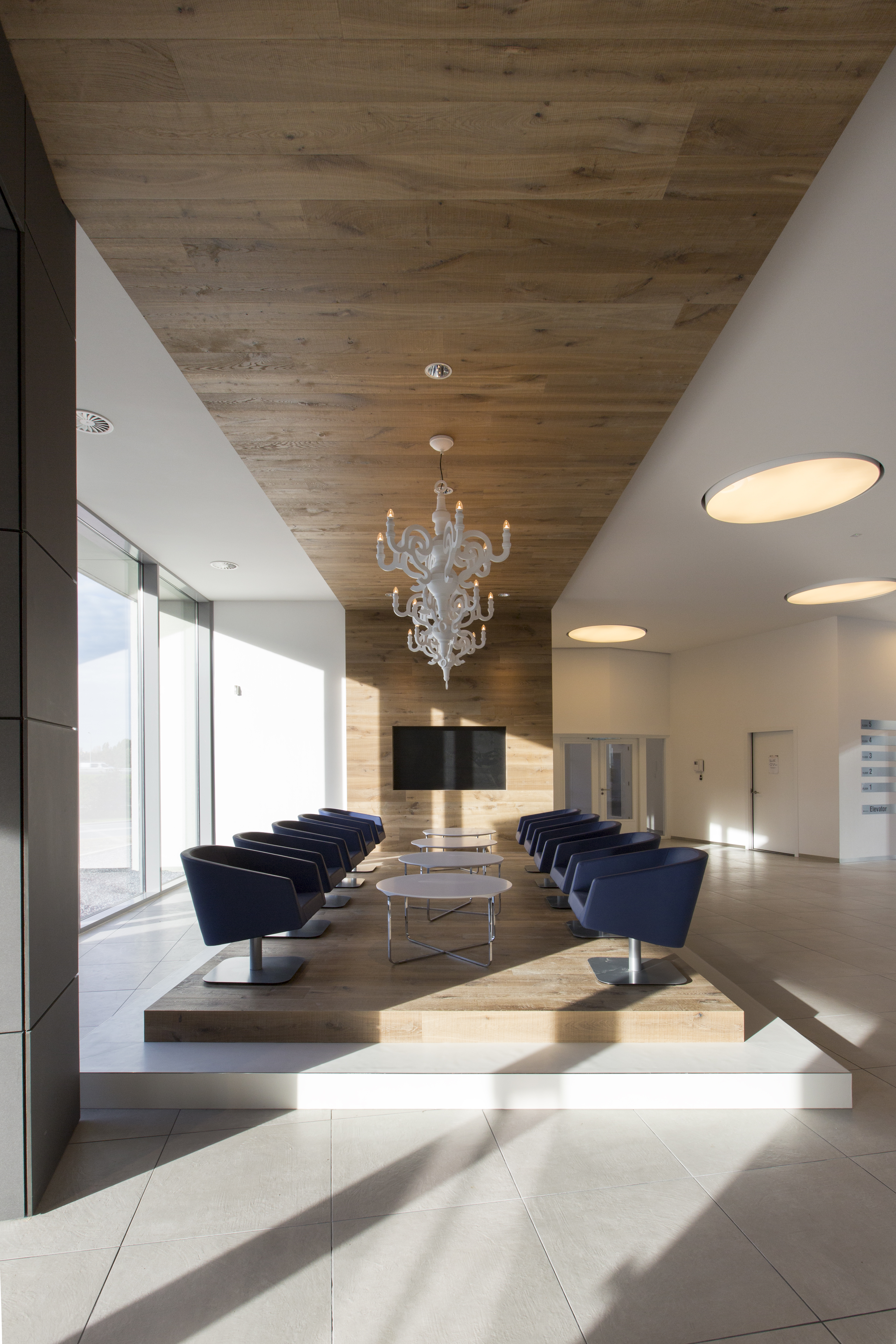 Bright, modern lounge area with large-format floor tiles and warm wood accents.