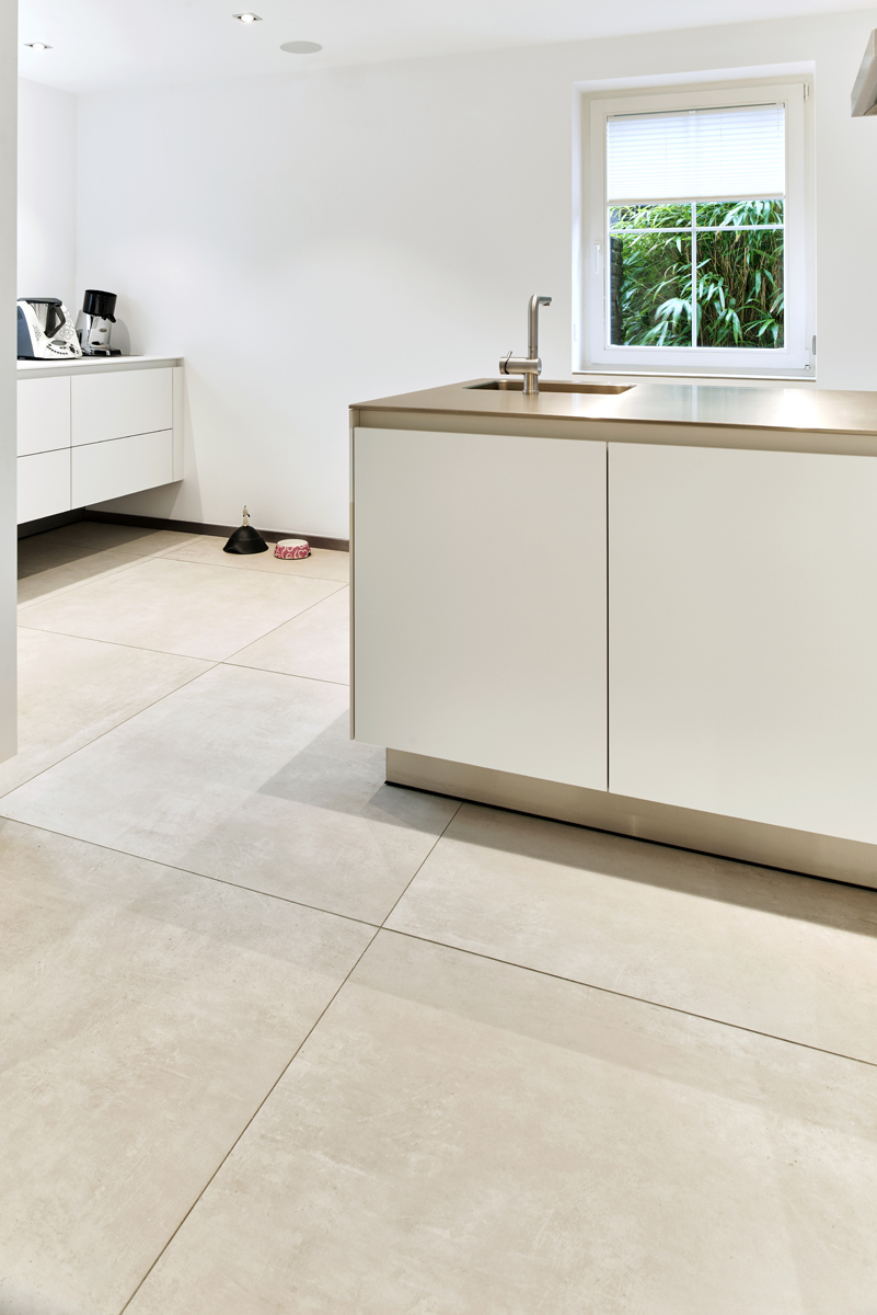 Large-format, light concrete-effect tiles for modern kitchens.