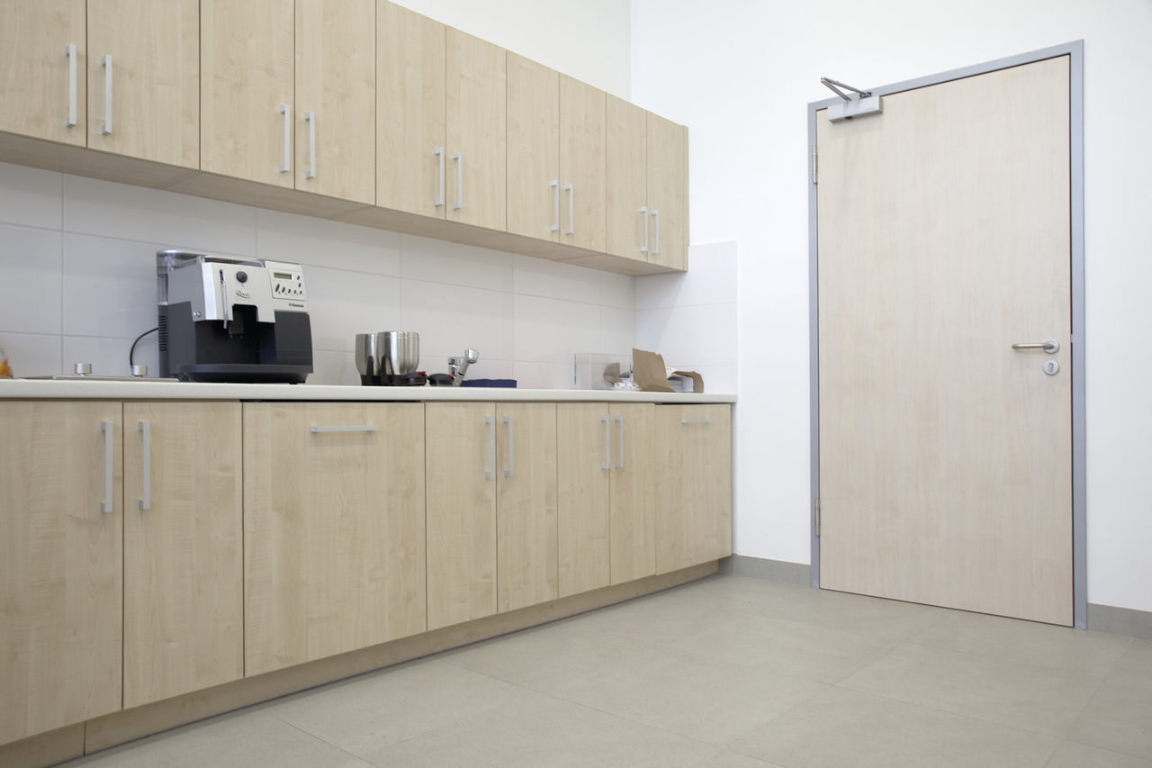 Large-format, light grey floor tiles in a modern kitchenette.