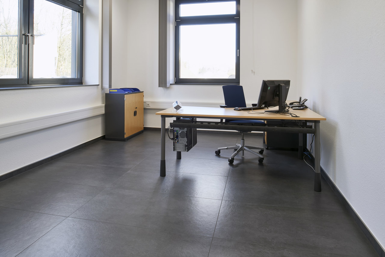 High-quality dark grey floor tiles in a modern office.