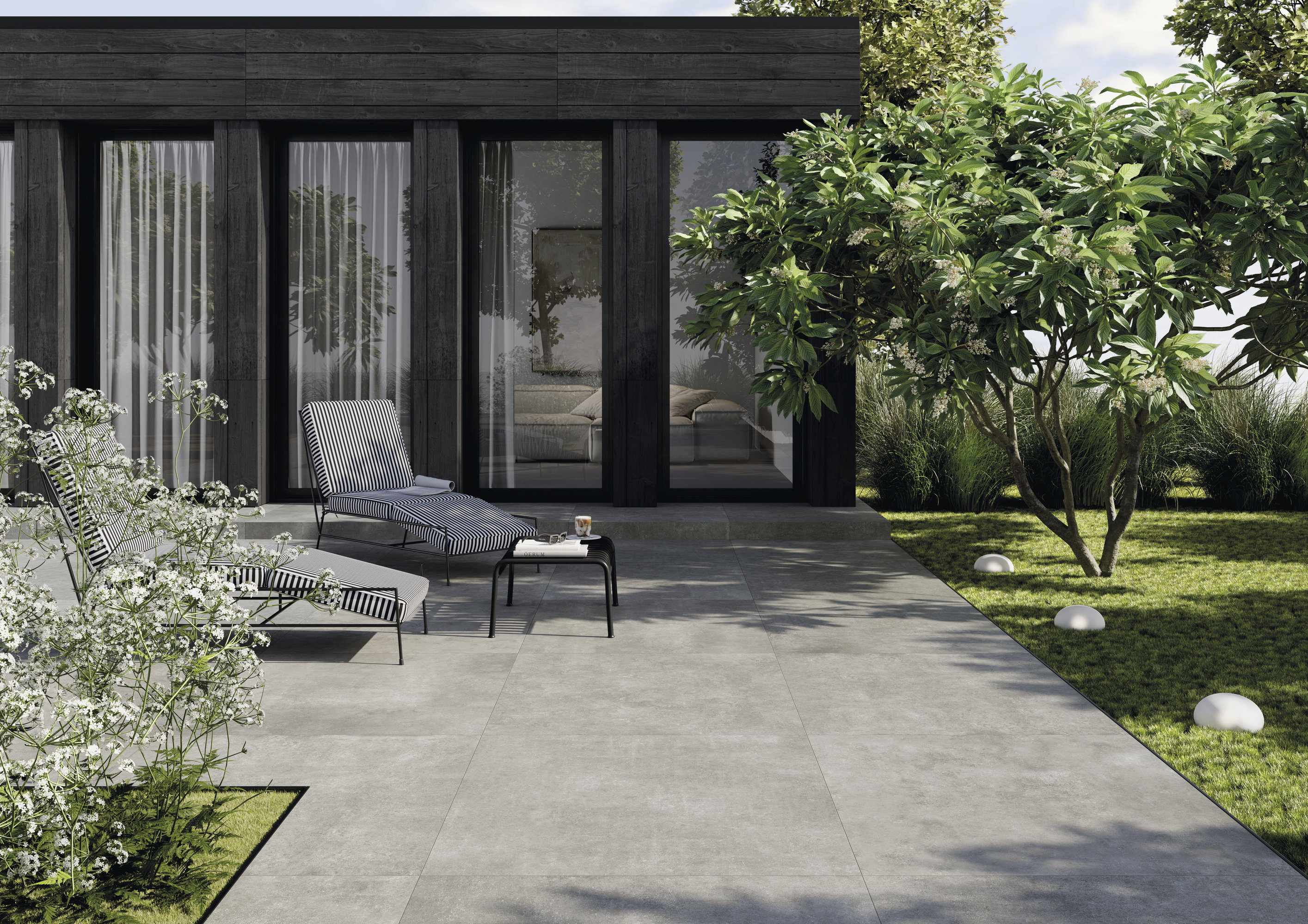 Modern terrace with light grey outdoor tiles and stylish lounge furniture.