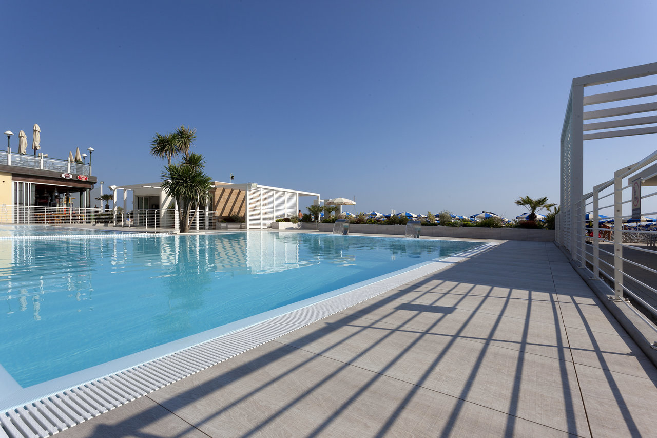 Light outdoor tiles at a modern complex's pool area.