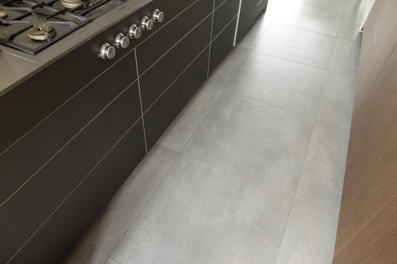 Bright, large-format concrete-look tiles for a modern kitchen.