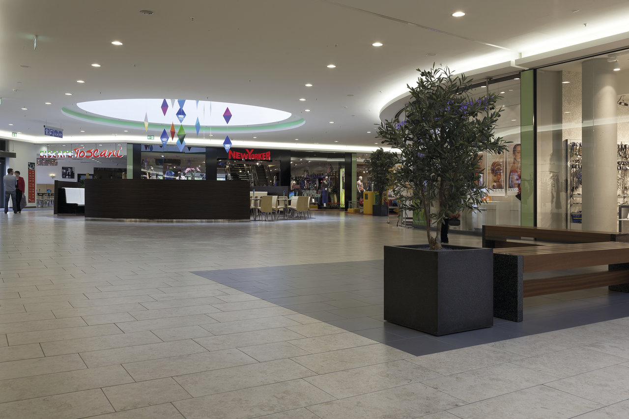Light, large-format floor tiles in a modern shopping center.